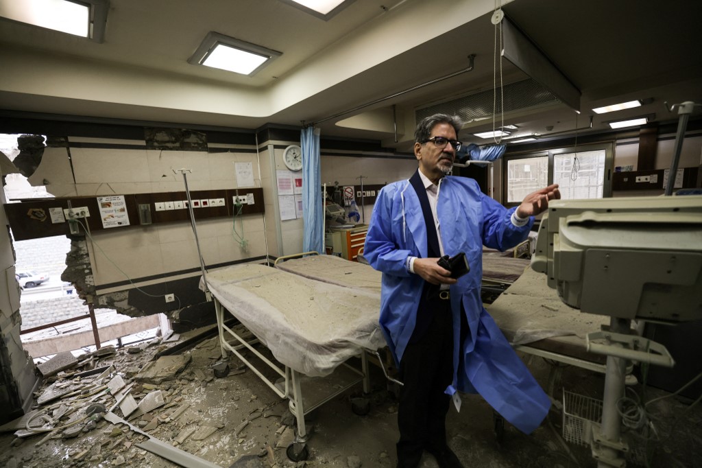 A doctor shows the damage inside the Gandi Hospital whichwas hit on 1 March during the ongoing joint US-Israeli military campaign on the capital Tehran on 2 March, 2026. (AFP)