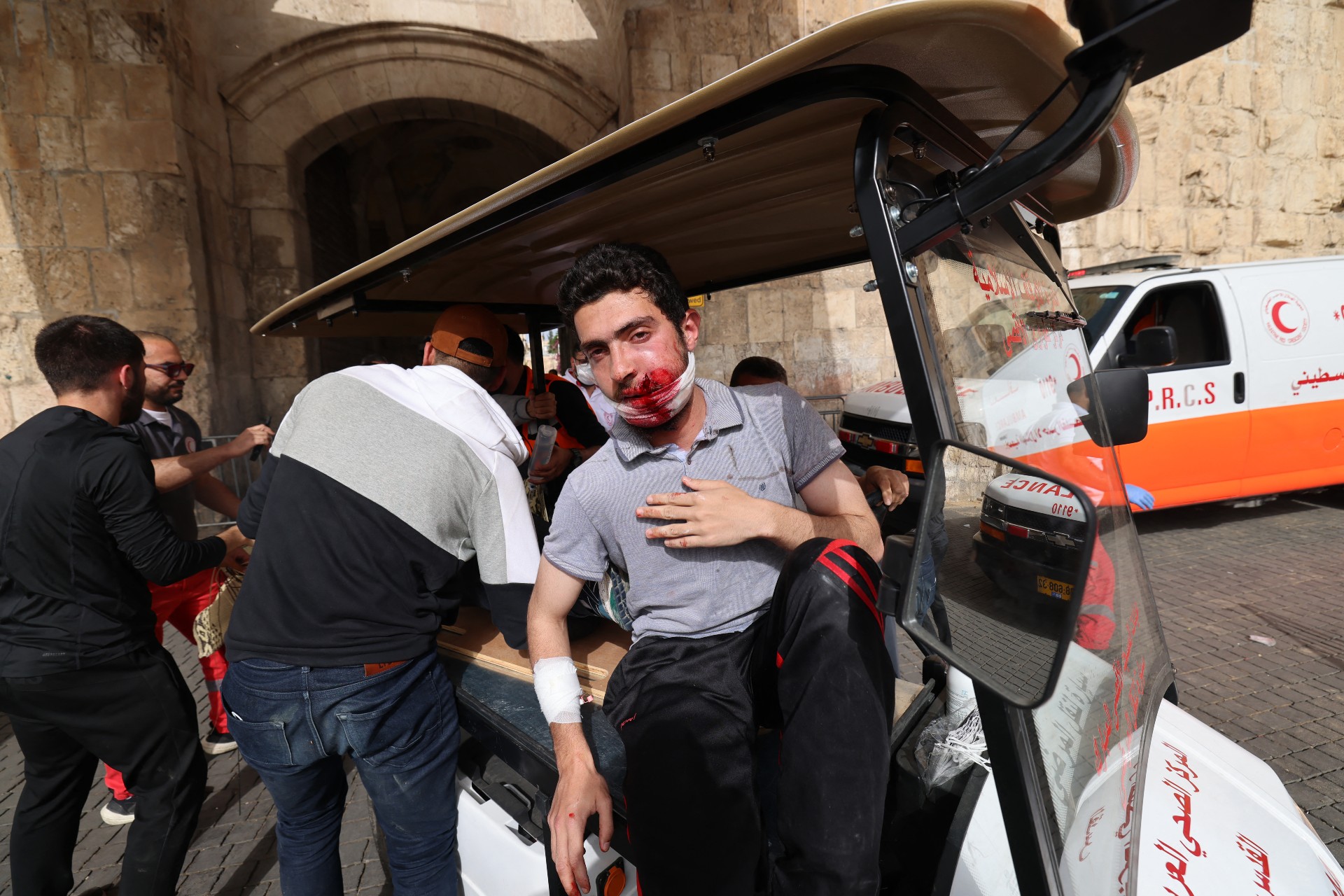 A wounded Palestinian waits to be transported by medics (AFP)