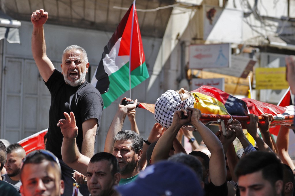 Relatives carry the body of 15-year-old Islam Wael Bernat during his funeral procession in in the city of al-Bireh, northeast of Ramallah (AFP)