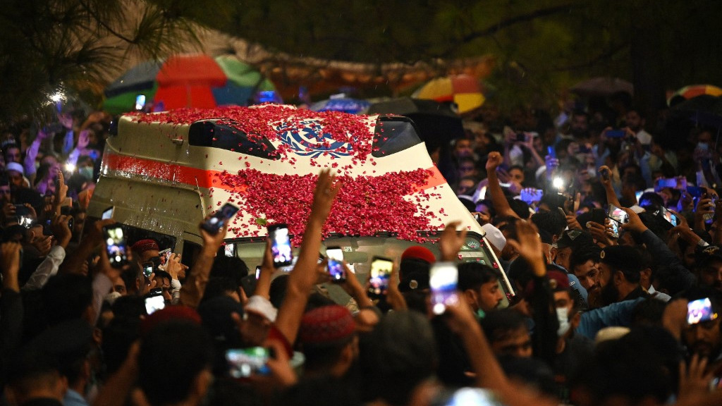 Supporters and officials gather around an ambulance carrying the coffin of AQ Khan following his death in Islamabad on October 10, 2021. (AFP)