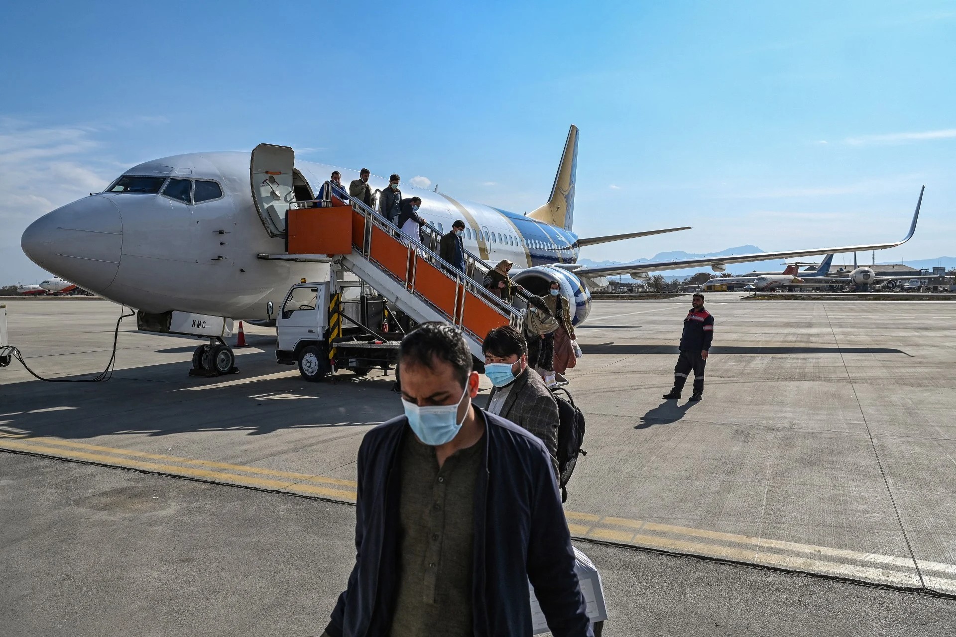 Afghans disembark at Kabul airport on arrival from Herat, on 24 November 2021 (AFP)