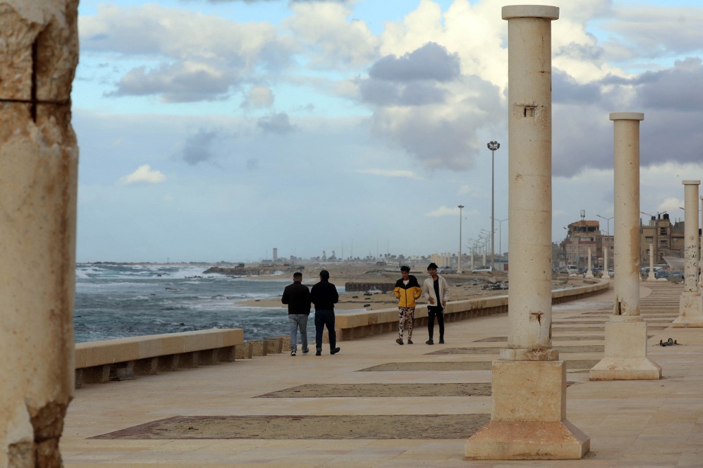 Des jeunes marchent le long de la promenade surplombant le front de mer méditerranéen à Benghazi, deuxième ville de l’est de la Libye (AFP/Abdallah DOMA)
