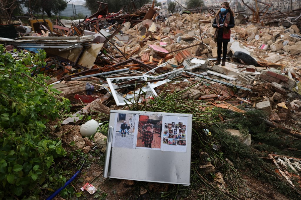 Family pictures are left on the ruins of the Palestinian Salhiya family's house, demolished by Israeli forces, on 19 January 2022. (Afp)