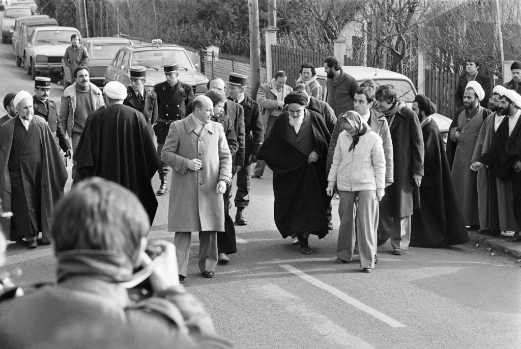 Rouhani (2nd R) s seen among companions of opposition leader in exile ayatollah Ruhollah Khomeiny (C-white beard) walking out of his villa in Neauphle-Le-Château near Paris on January 31, 1979 before boarding an Air France 