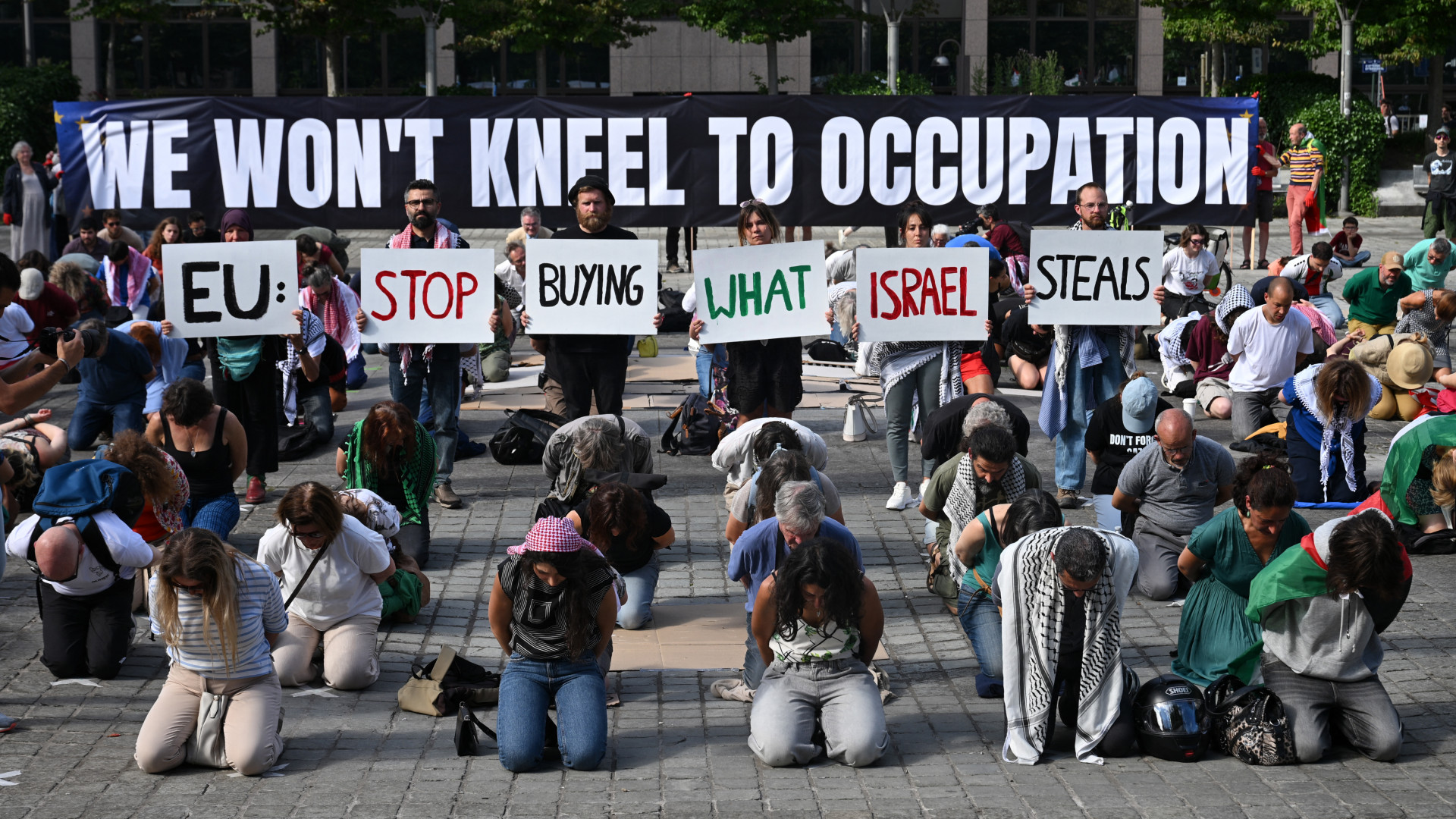 Activists hold placards reading 'EU: Stop buying what Israel steals' during a demonstration in Brussels calling on EU leaders to ban goods from illegal Israeli settlements on 17 June 2026