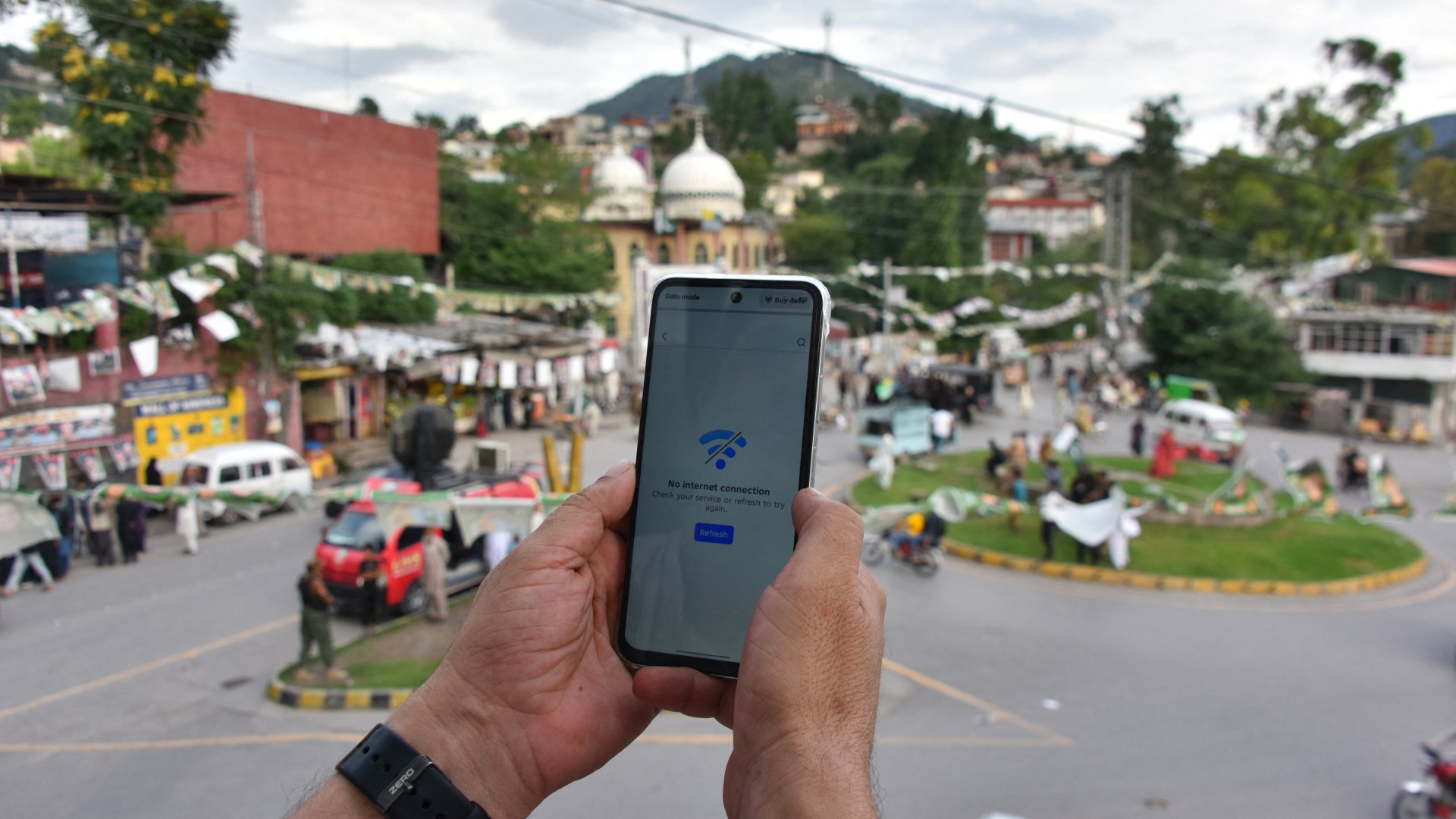 A Kashmiri searches for mobile phone signal following a partial internet shutdown imposed ahead of the first phase of the regional elections in Muzaffarabad on 23 July, 2026