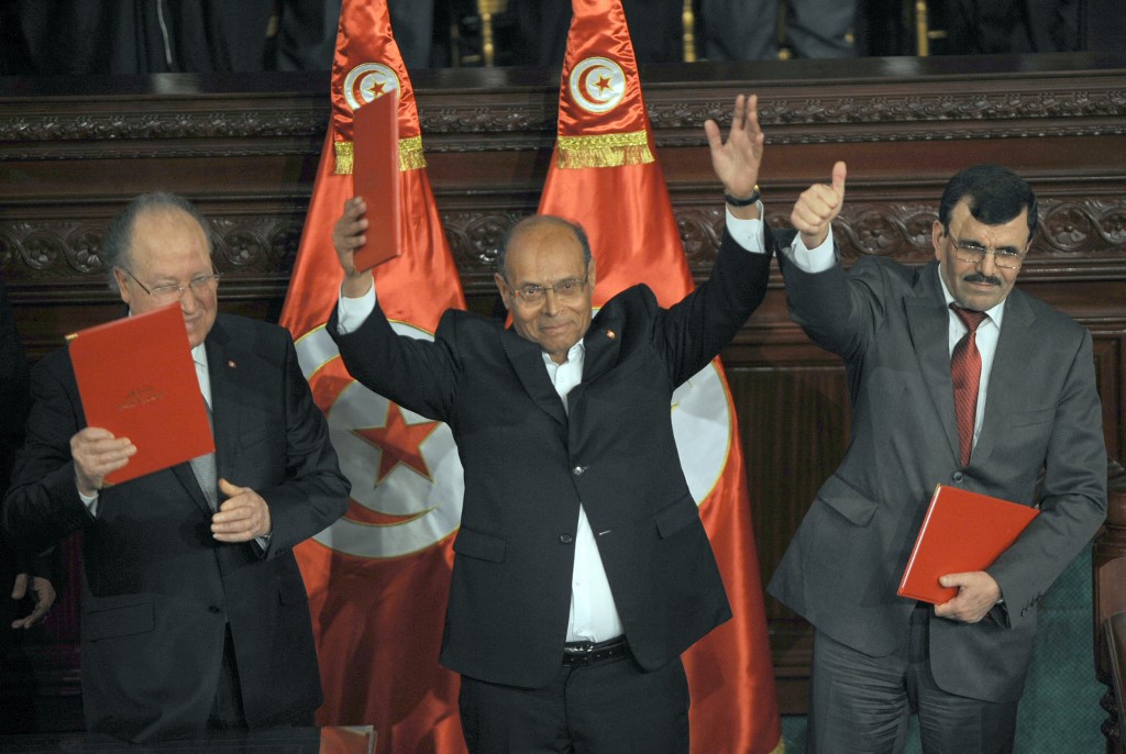 Politicians pose with Tunisia’s new Constitution on 27 January 2014 (AFP/Fethi Belaid)