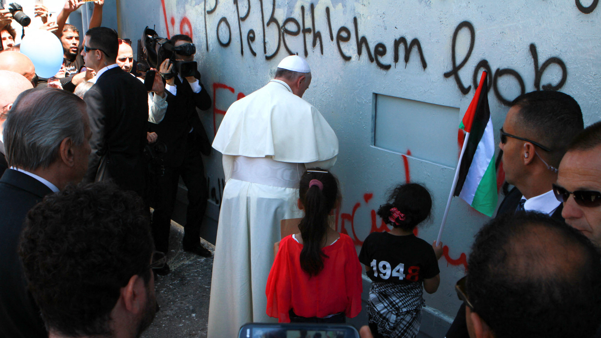 Pope Francis prays at Israel's separation barrier, after making an unscheduled stop at the towering concrete wall in the West Bank town of Bethlehem, on 25 May 2014 (Taufiq Khalil/AFP)