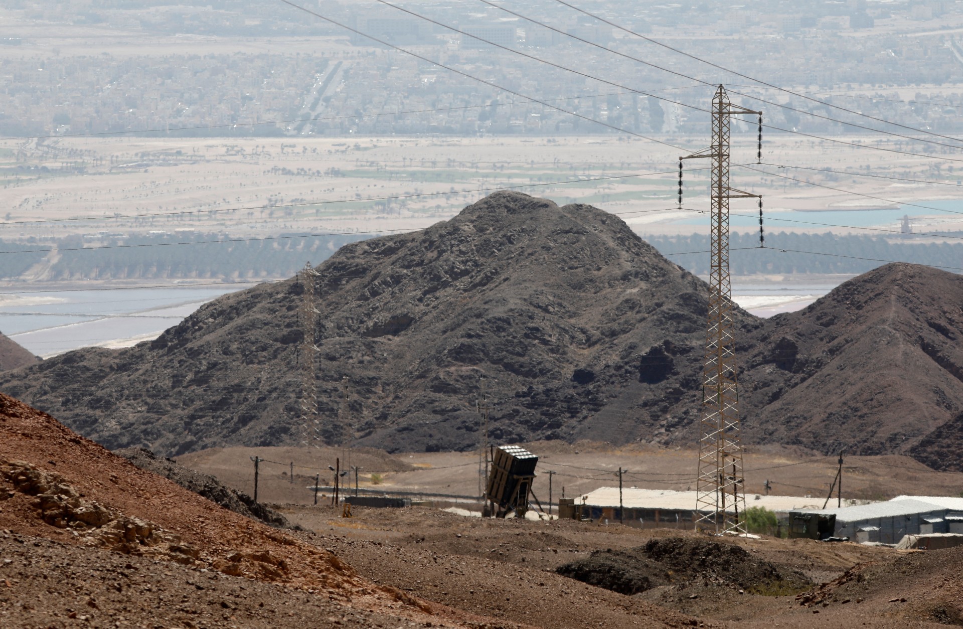 Israel's Iron Dome system deployed in the southern Negev desert, north of the Israeli city of Eilat, and the Jordanian city of Aqaba seen in the background (AFP)