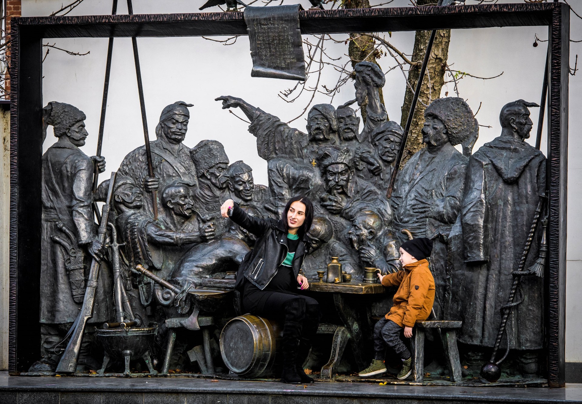 A woman takes a selfie in front of a sculpture depicting the 