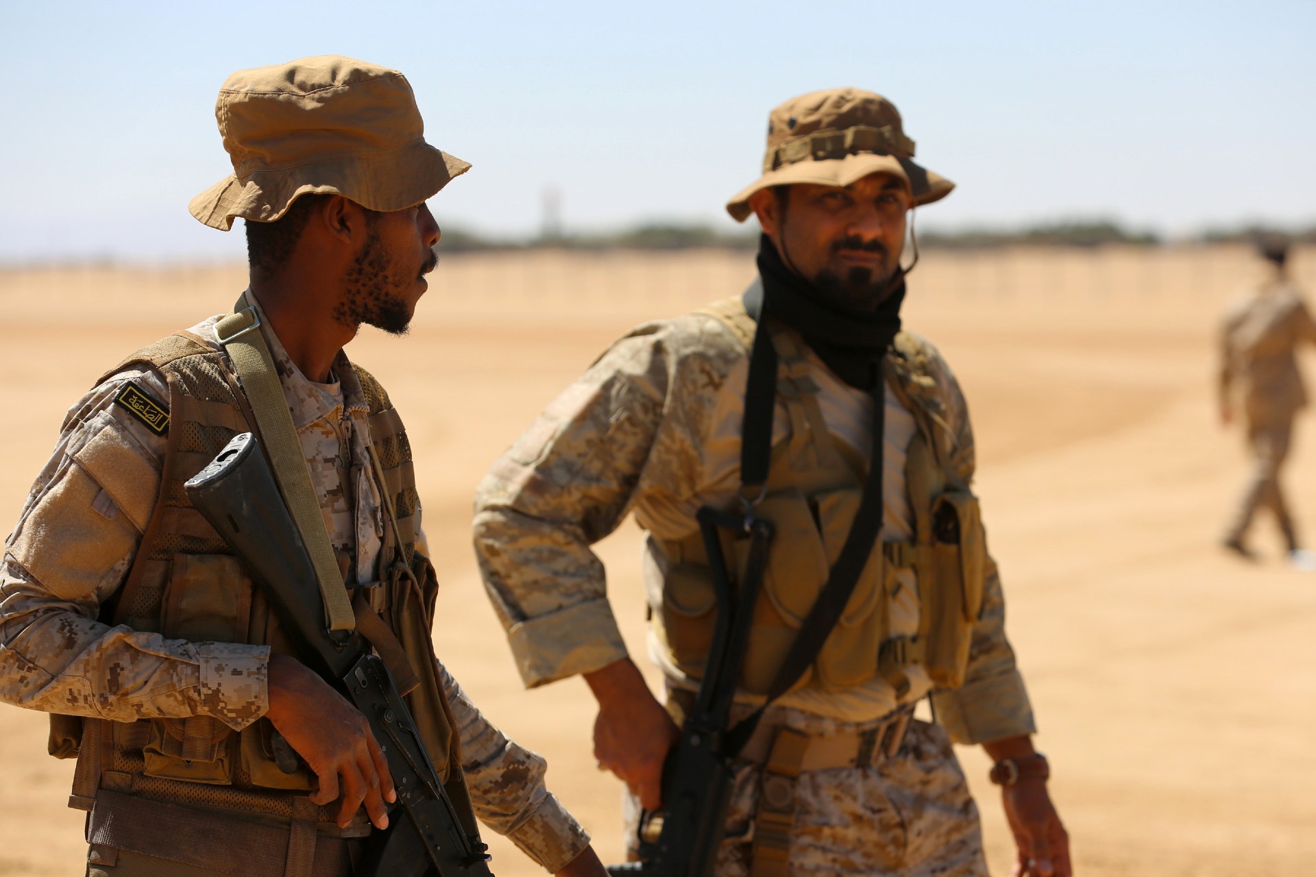 Saudi soldiers stand guard as workers unload aid from a Saudi air force cargo plane at an airfield in Yemen's central province of Marib (AFP)