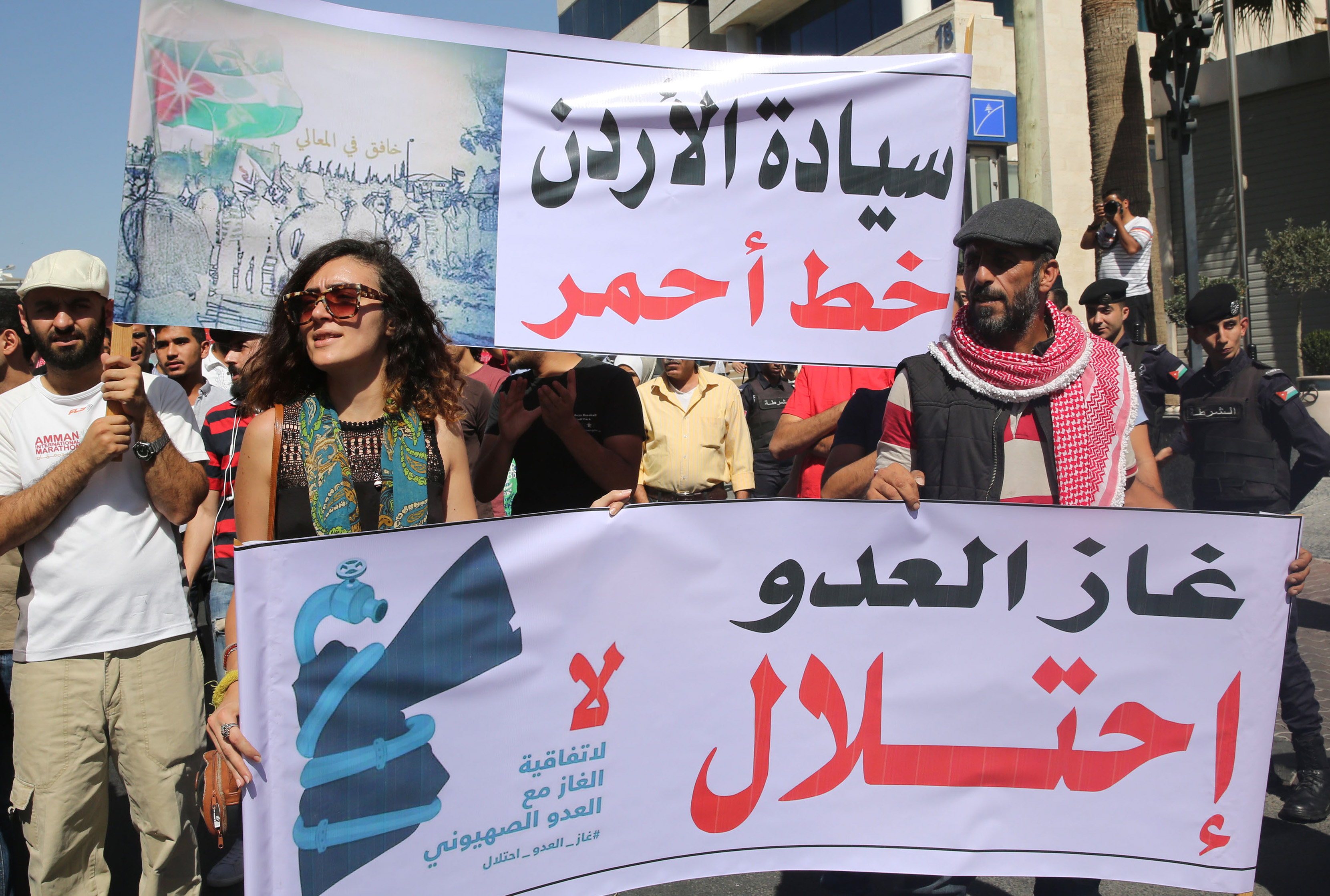 Jordanian protesters hold slogans reading, 