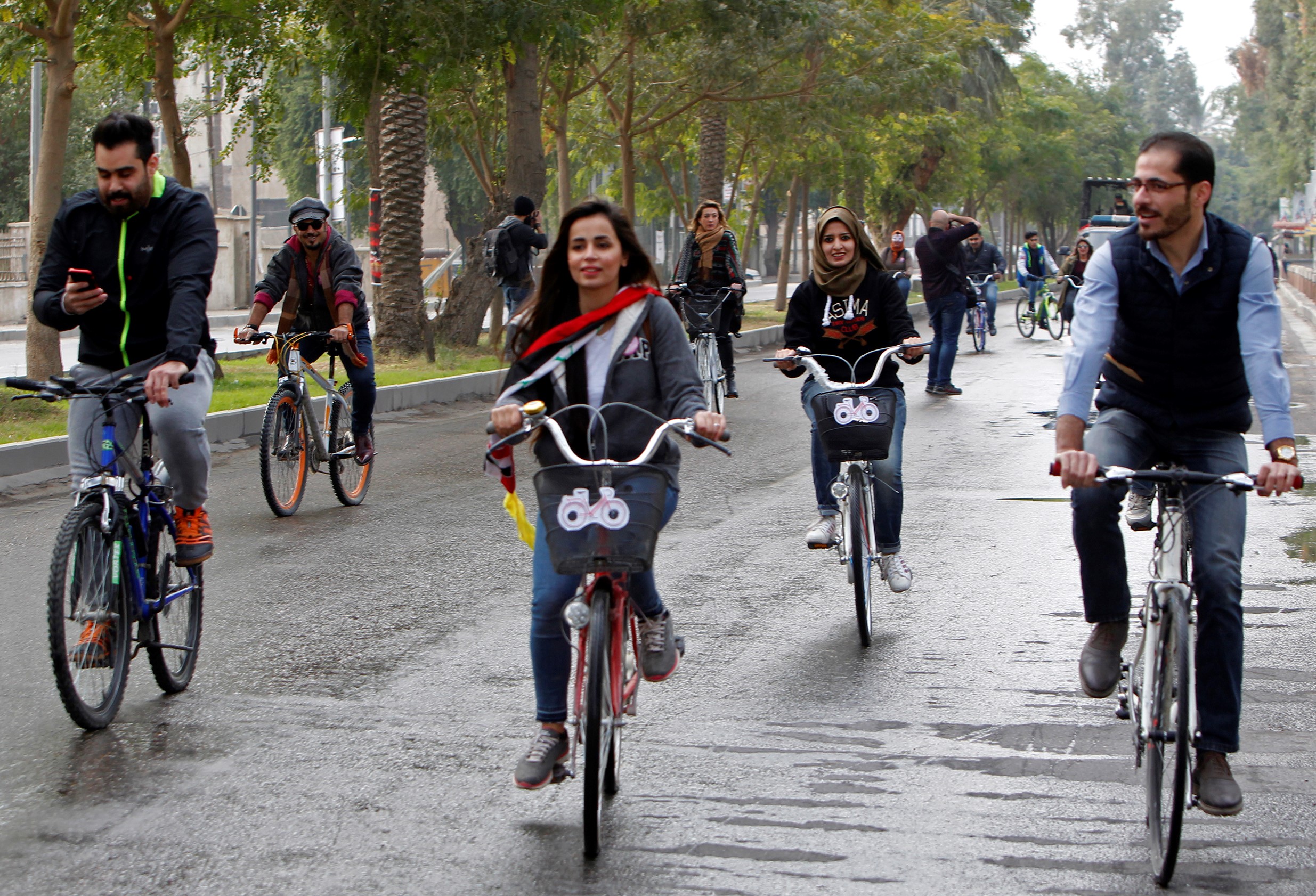  Iraqi Marina Jaber, 25, rides a bicycle among others on Baghdad's Abu Nawas street on 5 December, 2016 (AFP)