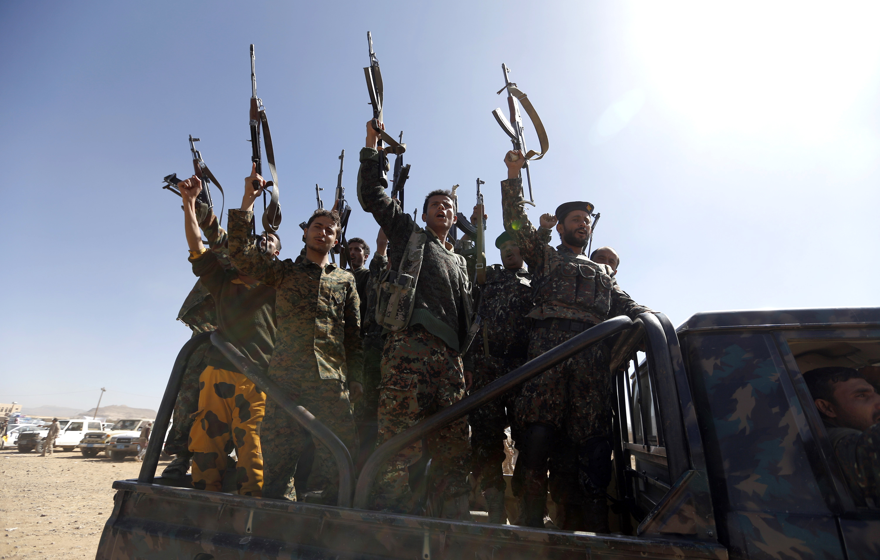 Newly recruited Houthi fighters chant slogans as they ride a military vehicle during a gathering in the capital Sanaa (AFP)