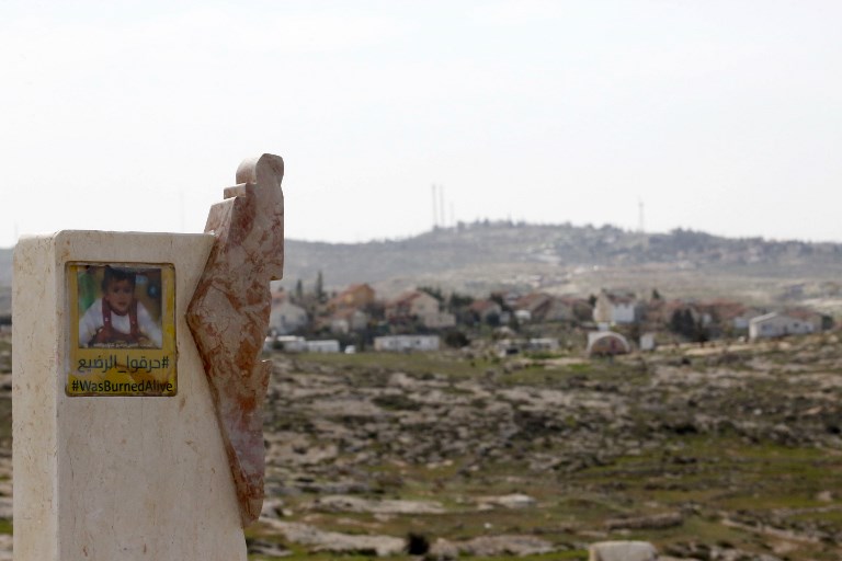 A placard bears the portrait of Ali Dawabsheh, an 18-month-old Palestinian boy killed in a 2015 firebombing near Hebron (AFP)