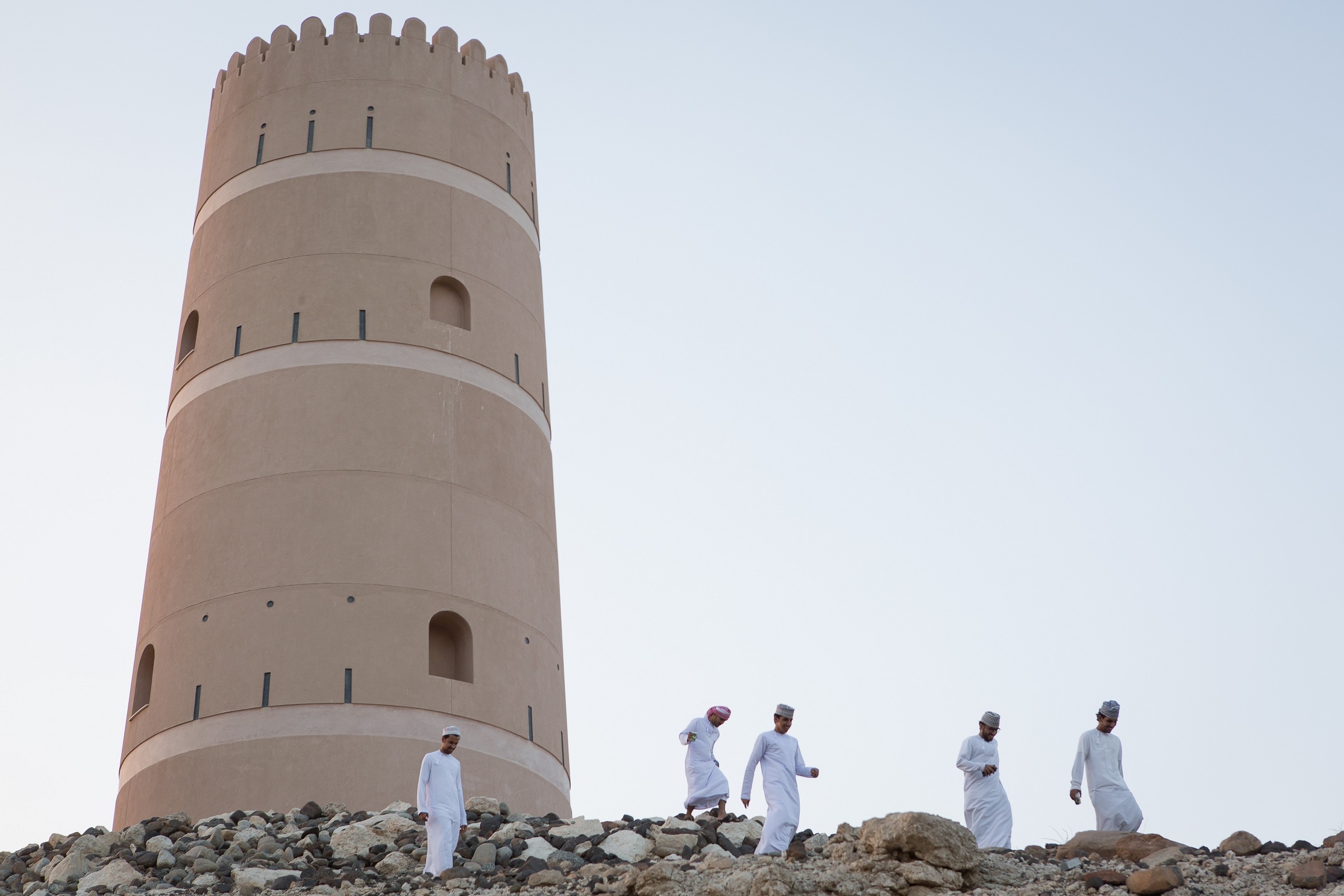 Omani bachelor students run down a hill near Sultan Qaboos University, the only public university in the Sultanate of Oman.