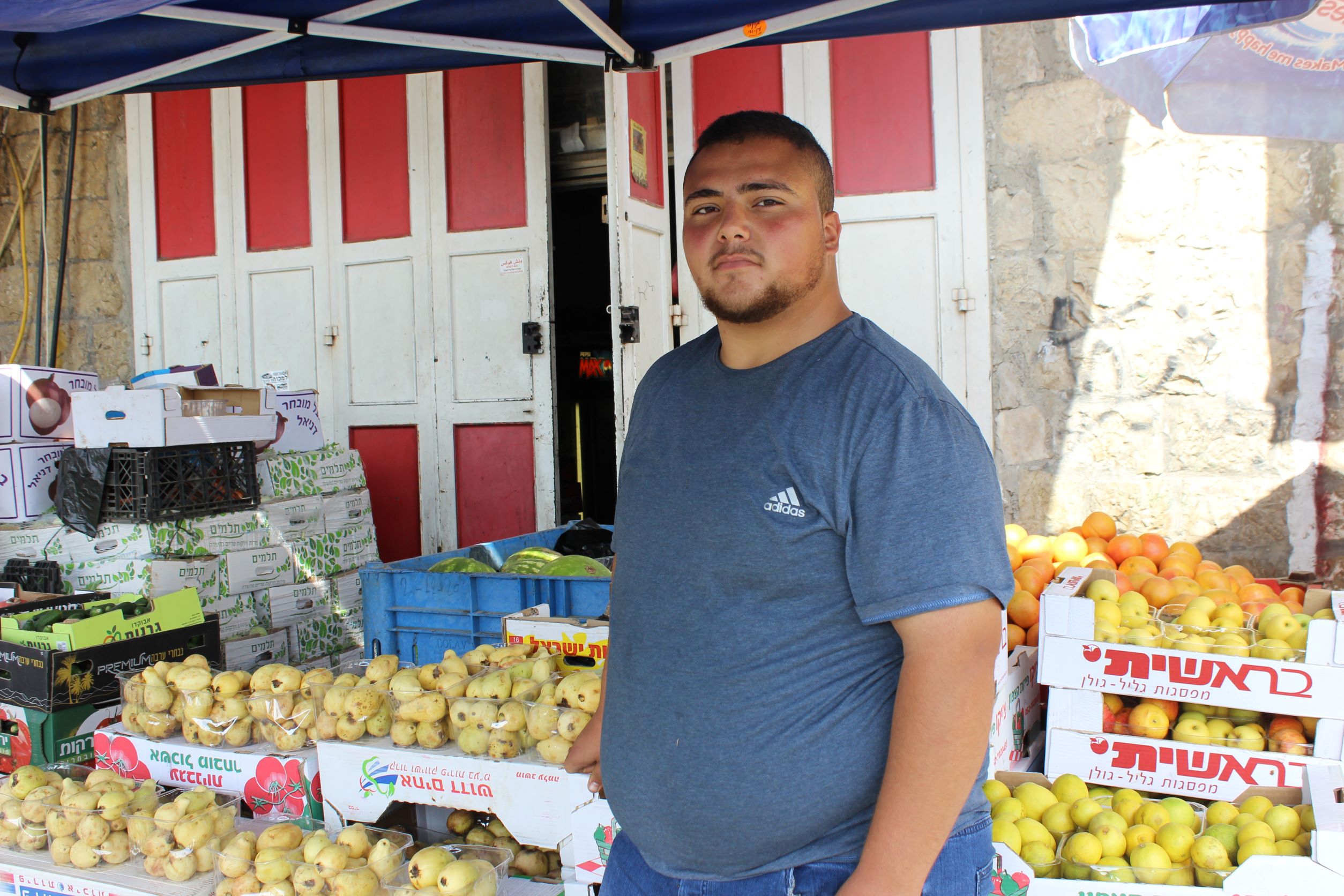 Vendor Yazan Maswadeh, standing with his products (Aseel Jundi)