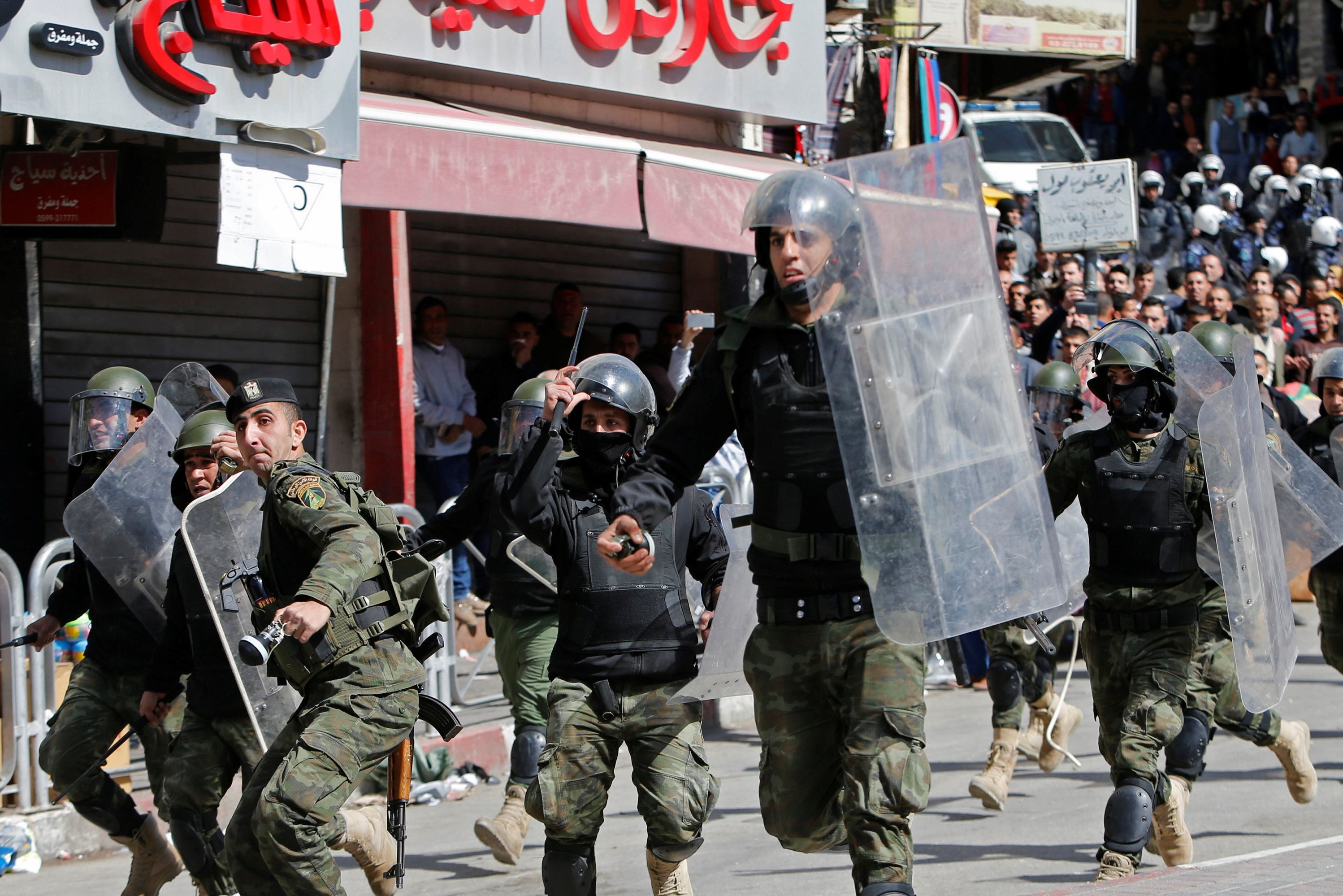   Members of the Palestinian security forces clash with demonstrators during a protest in the West Bank city of Hebron on 25 February, 2017 (Reuters)
