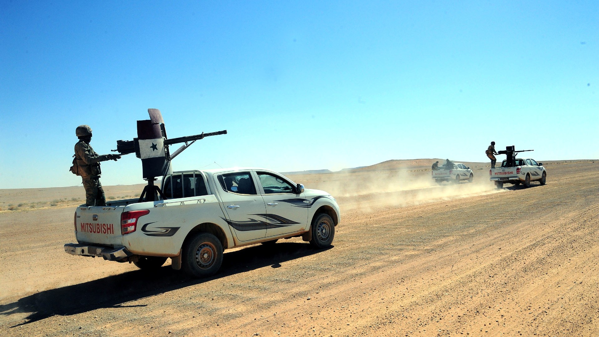 Forces loyal to Syria's President Bashar al-Assad ride on pick-up trucks mounted with weapons in the Badia, in the southeast Syrian desert, in 2017 (Reuters)