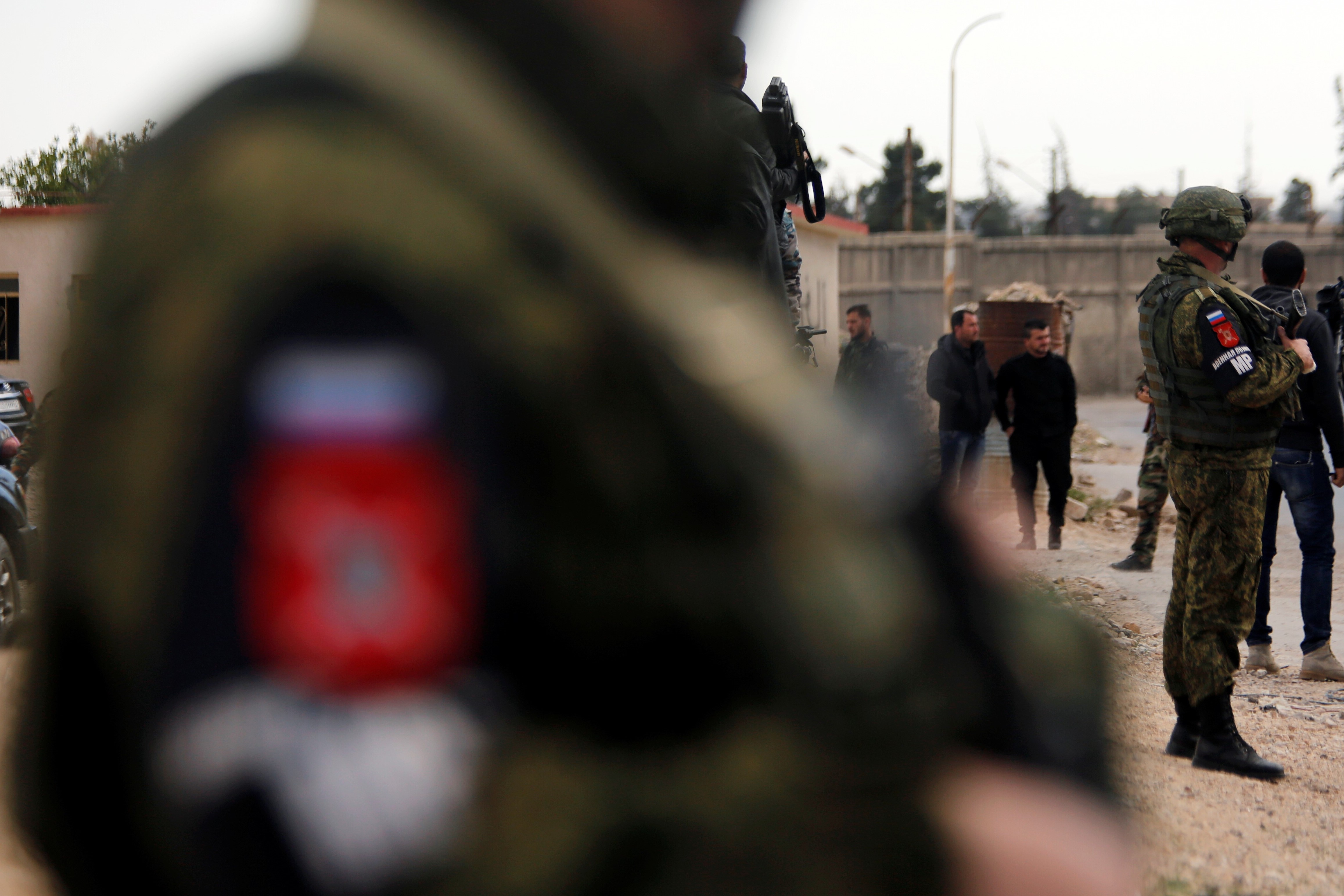 Russian soldiers secure an area where journalists wait for aid convoy returning from eastern Ghouta in Damascus, Syria March 9, 2018