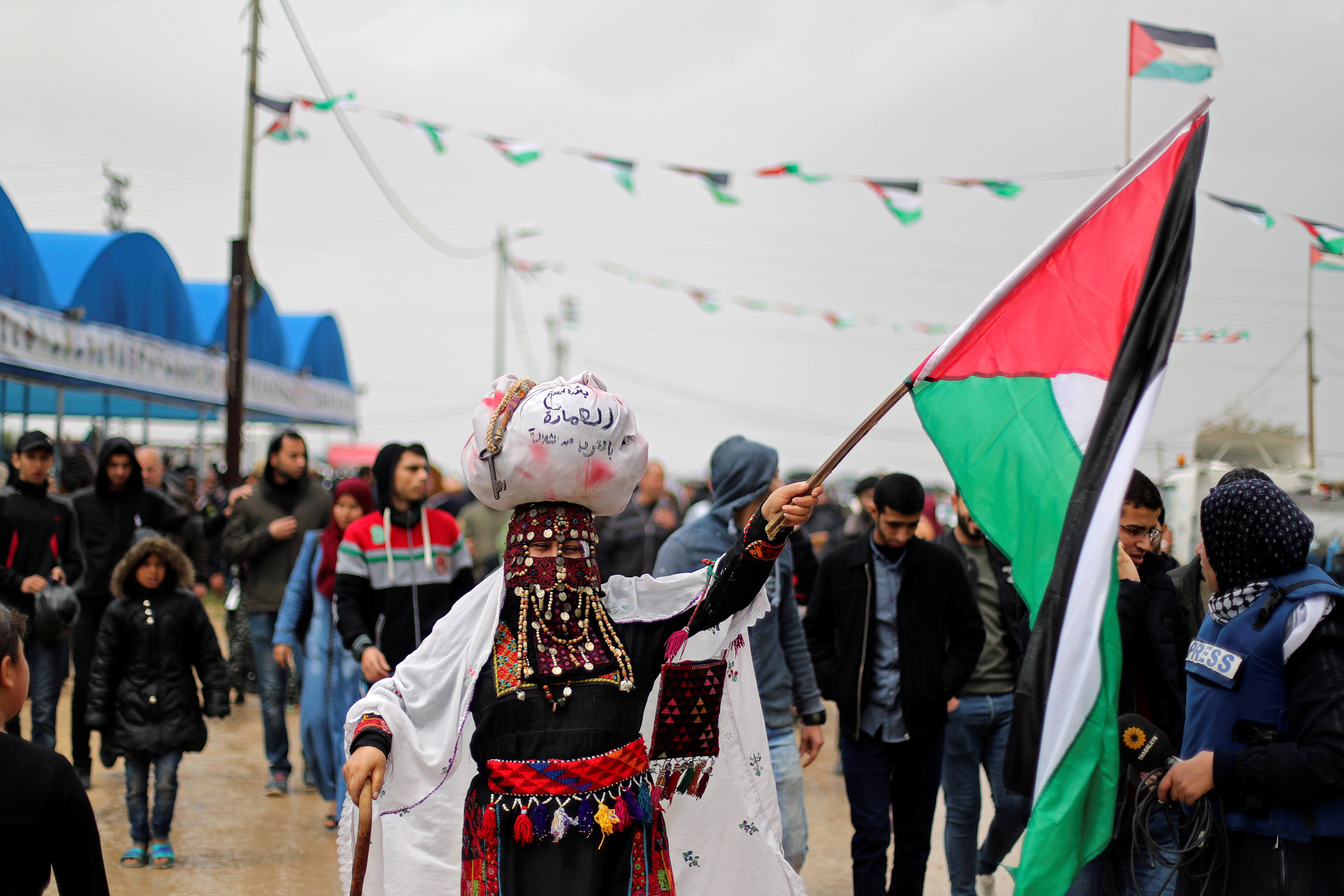 A woman holds a Palestinian flag east of Gaza City (Reuters)
