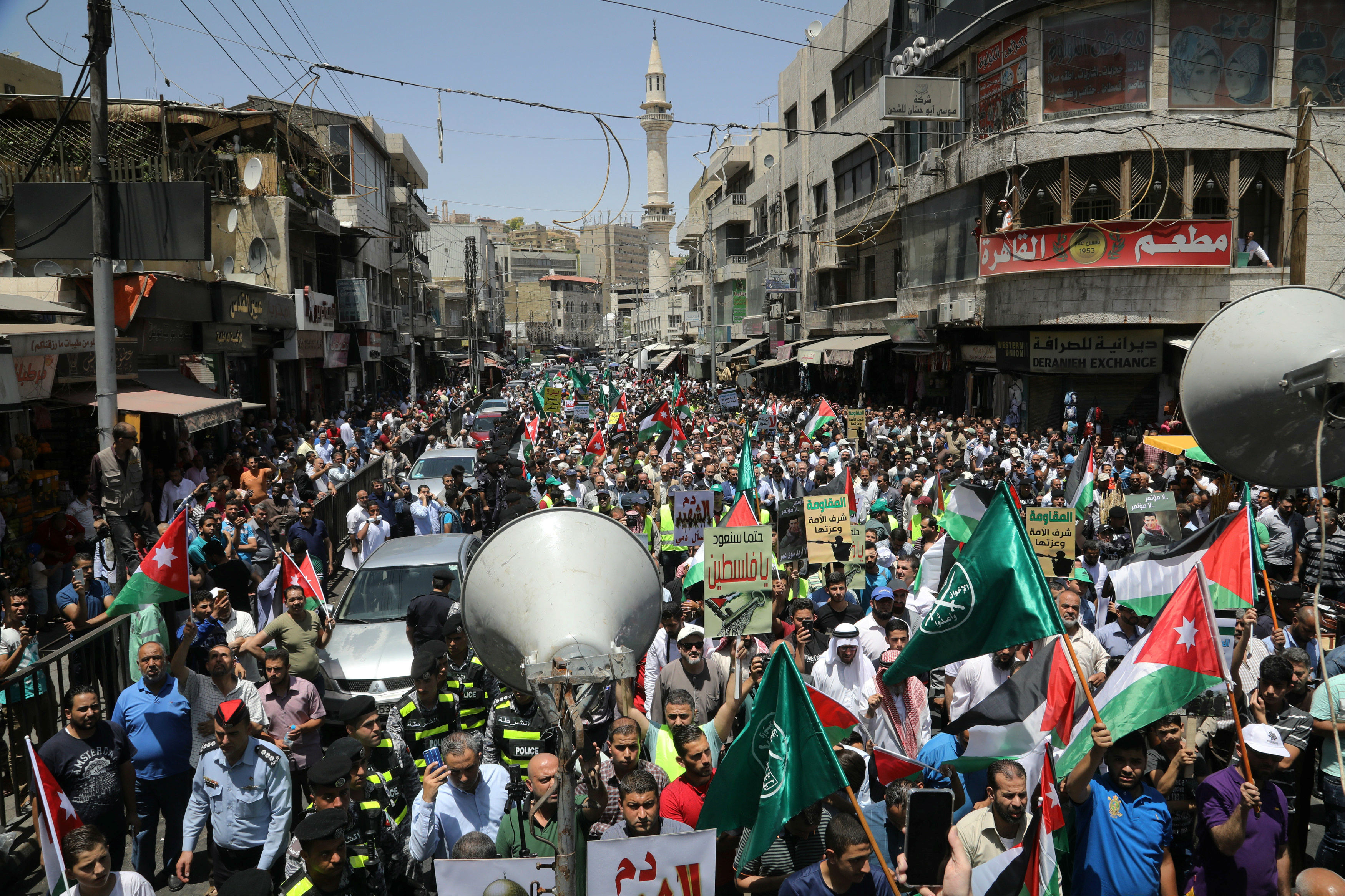Jordanian protesters hold Jordanian national flags as they chant slogans during a protest against U.S. President Donald Trump's 
