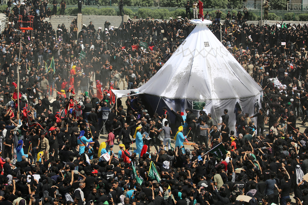 Iraqi Shia Muslims gather around a tent as they re-enact a scene from the 7th century battle of Kerbala during a ceremony marking Ashura in the holy city of Karbala (Reuters)