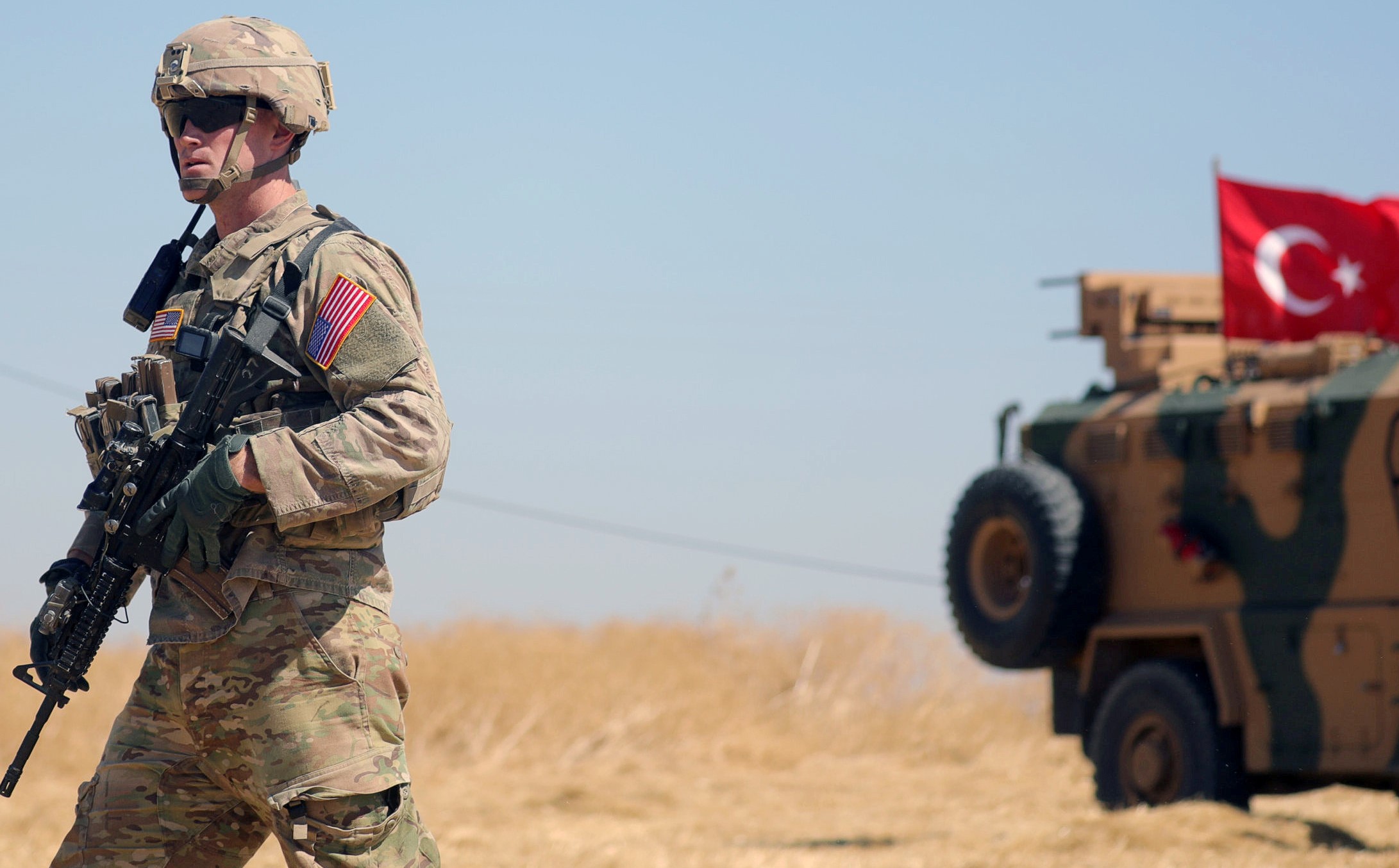 An American soldier walks near a Turkish military vehicle during a joint U.S.-Turkey patrol, near Tel Abyad, Syria September 8, 2019.