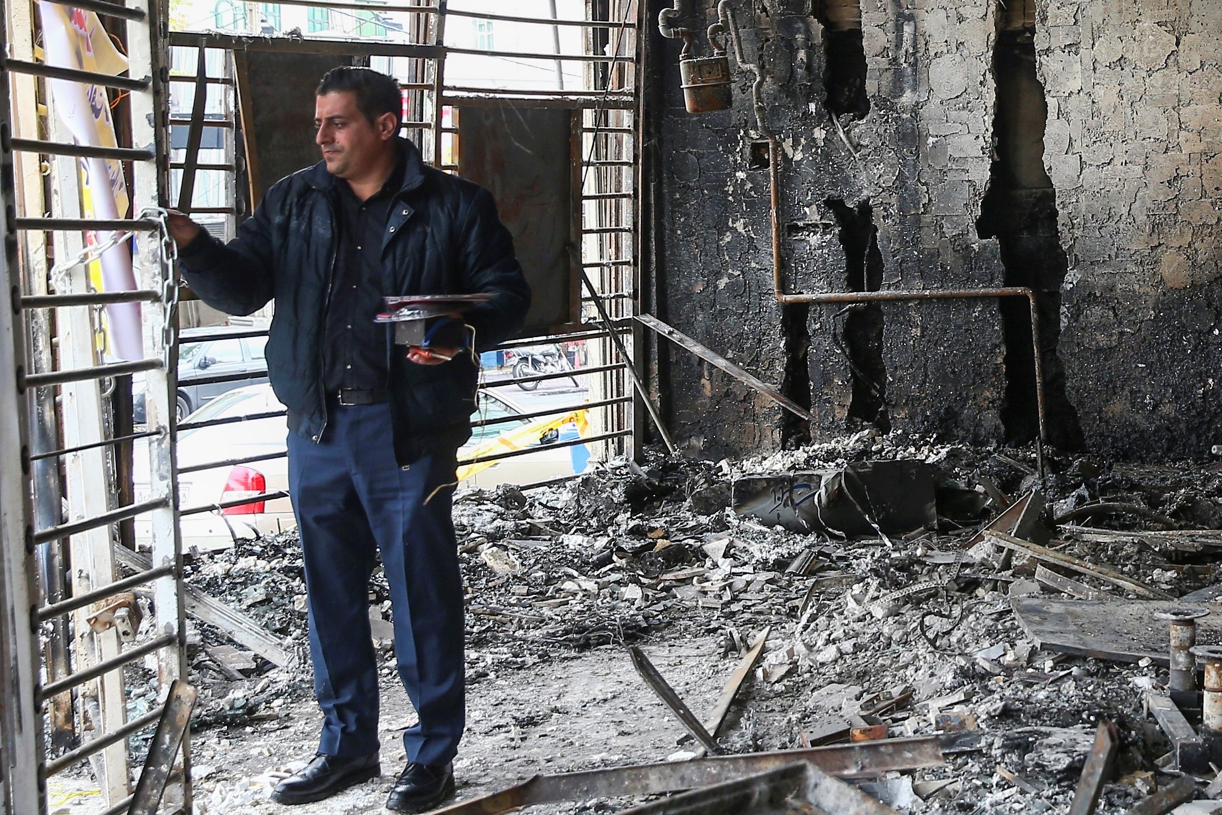 A man inspects the ruins of a bank after protests against increased fuel prices, in Tehran, Iran November 20, 2019. Picture taken November 20, 2019