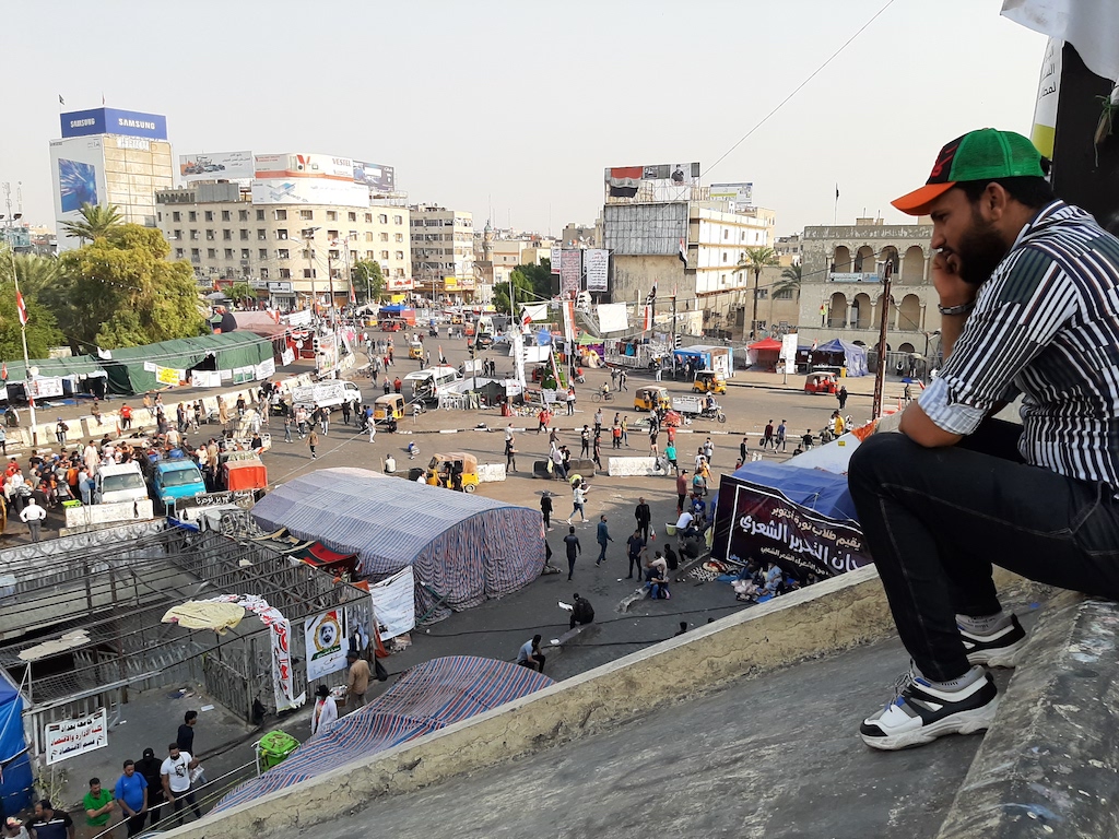 A protester sits at the edge of one of the lower floors of the 
