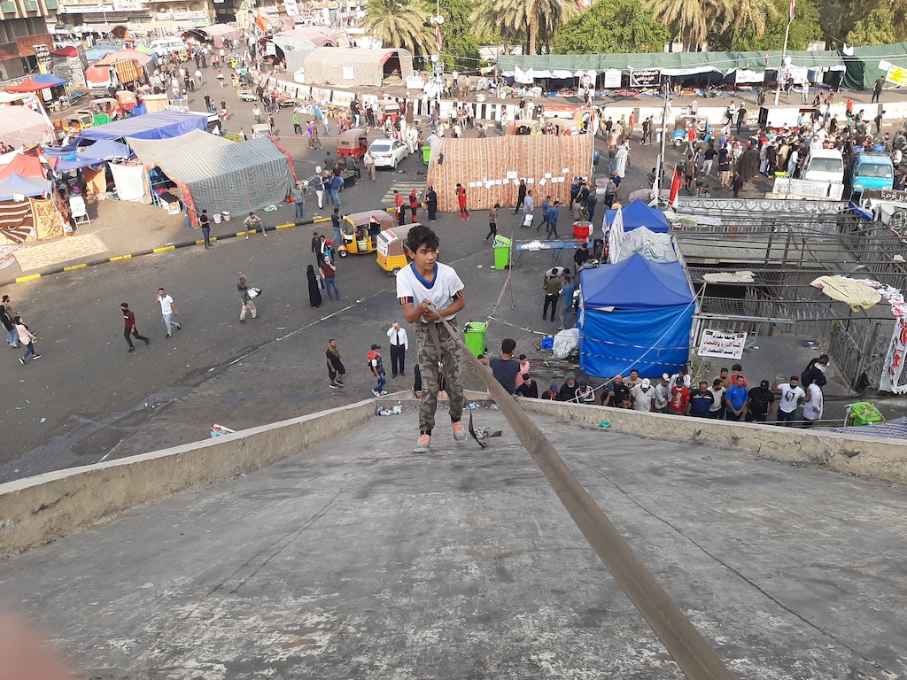 A young boy climbs a rope down the side of the 'Turkish Restaraunt' (Alex MacDonald)
