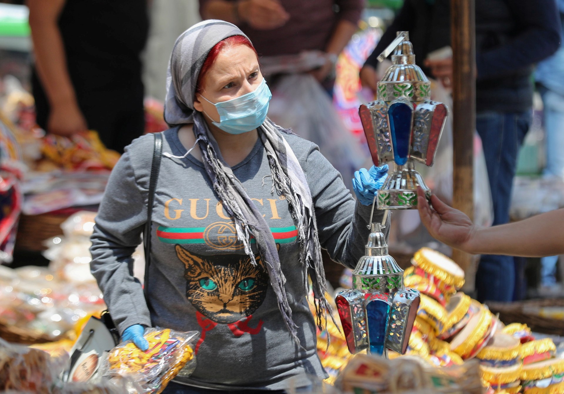 A woman wearing a protective face mask buys traditional Ramadan lanterns in Cairo (Reuters)