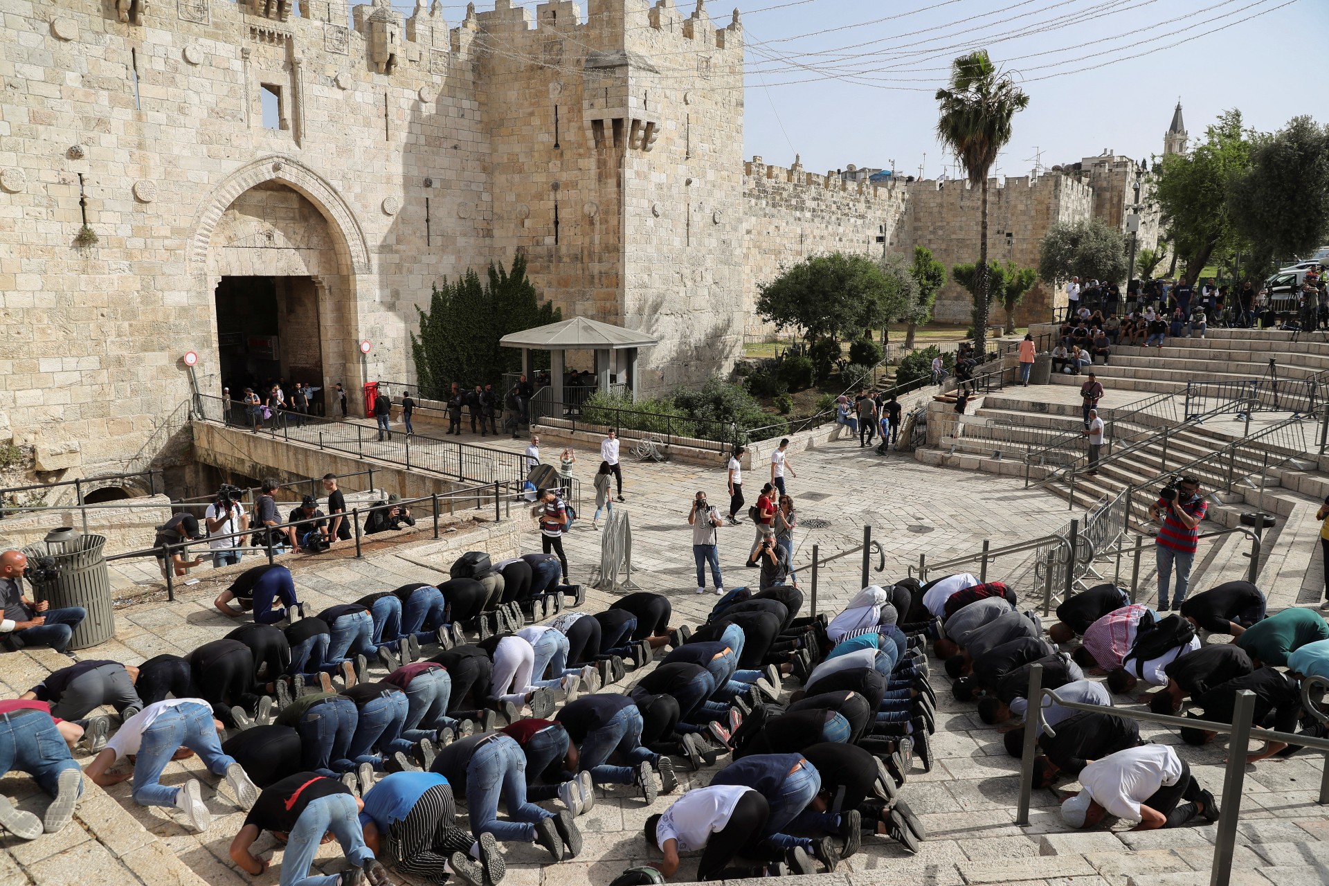 Palestinians pray after an Israeli raid on al-Aqsa Mosque, at Damascus Gate (Reuters)