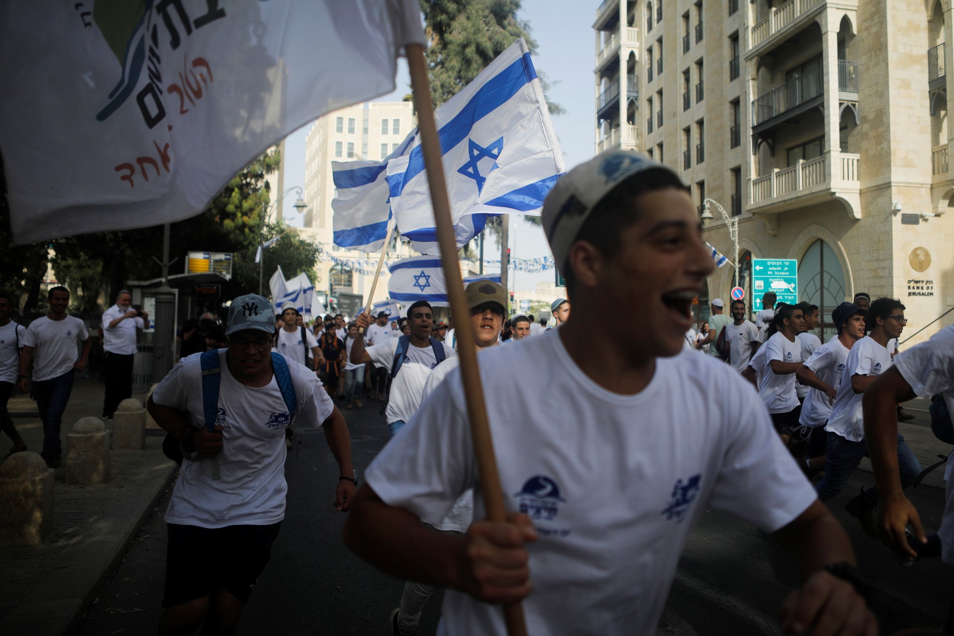 Youths wave Israeli flags during a parade marking Jerusalem Day, amid Israeli-Palestinian tension (Reuters)