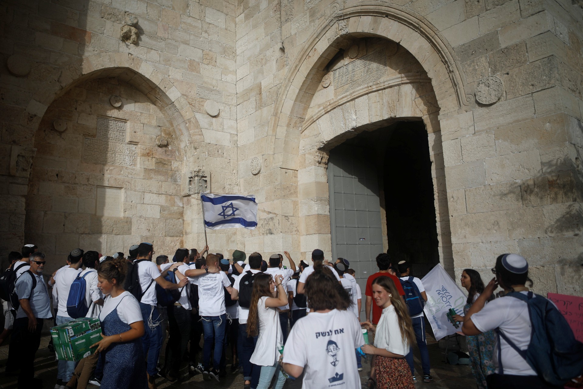 Youths wave an Israeli flag during a parade marking Jerusalem Day, amid Israeli-Palestinian tension, as they enter through Jaffa Gate in Jerusalem's Old City (Reuters)