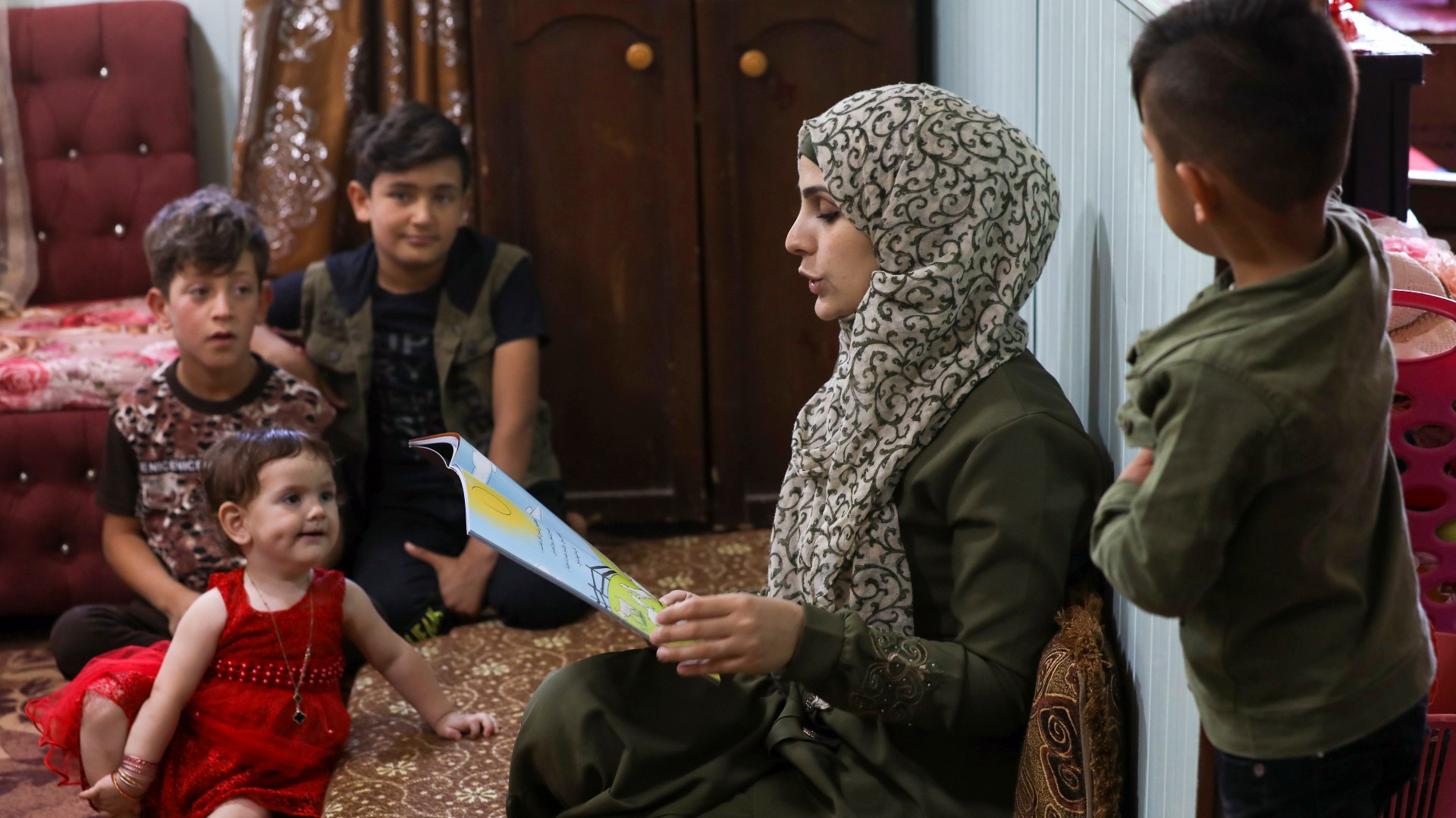 A Syrian refugee storyteller living in Zaatari refugee camp, reads a story to children at the Jordanian camp (Reuters/File photo)