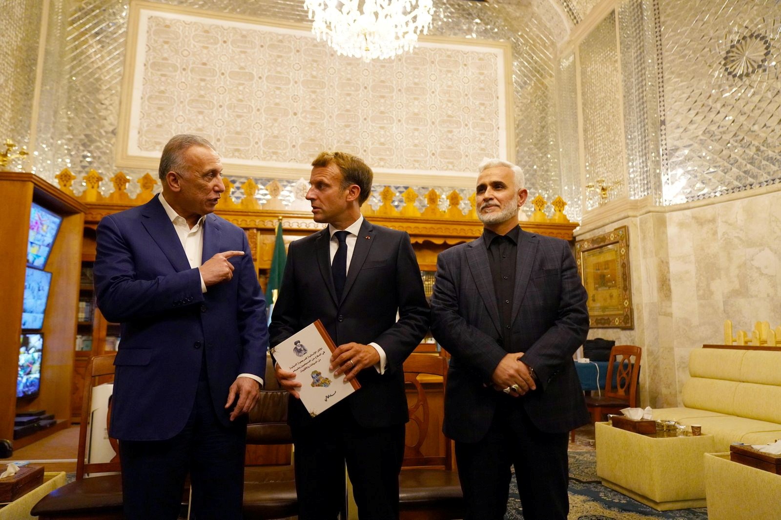 Iraqi Prime Minister Mustafa al-Kadhimi speaks with French President Emmanuel Macron as they visit the Shrine of Imam Moussa al-Kadhim in Baghdad (Reuters)