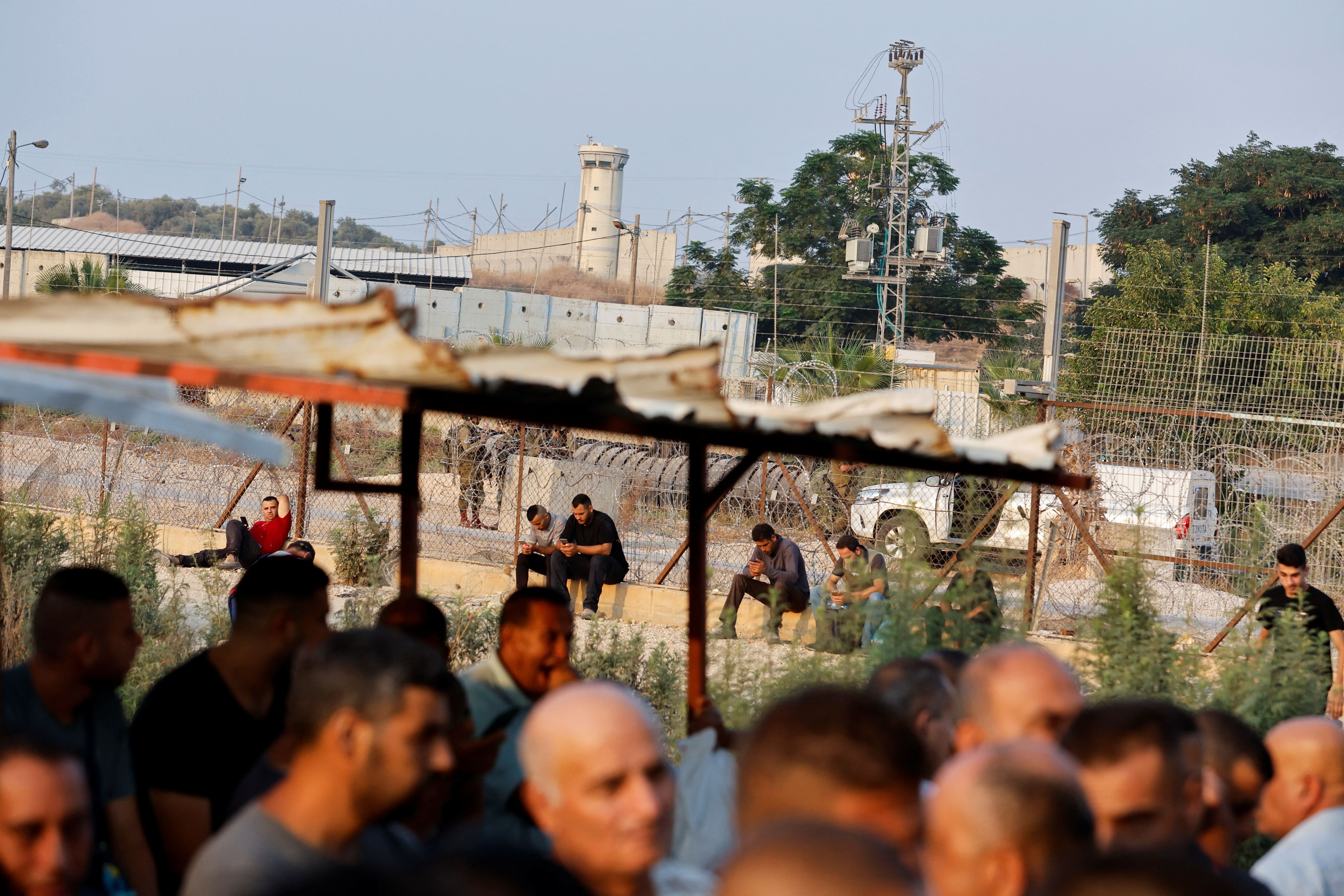 Palestinian workers in Israel strike against new arrangement to have their wages transferred to bank accounts, at an Israeli checkpoint in Tulkarm in the occupied West Bank on 21 August 2022 (Reuters)