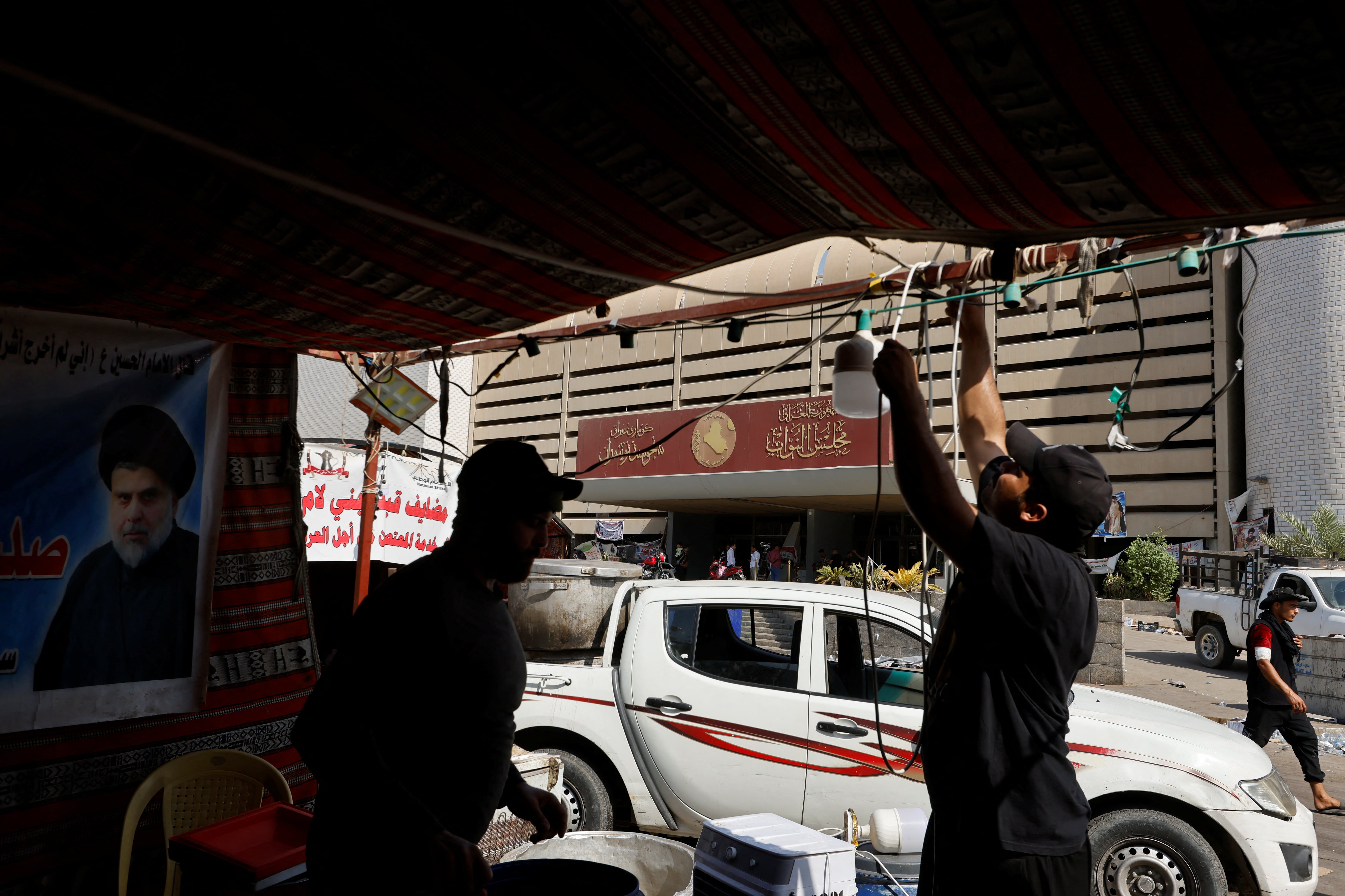 Followers of Iraqi cleric Muqtada al-Sadr dismantle their tents outside the parliament at the Green Zone in Baghdad on 30 August 2022 (Reuters)