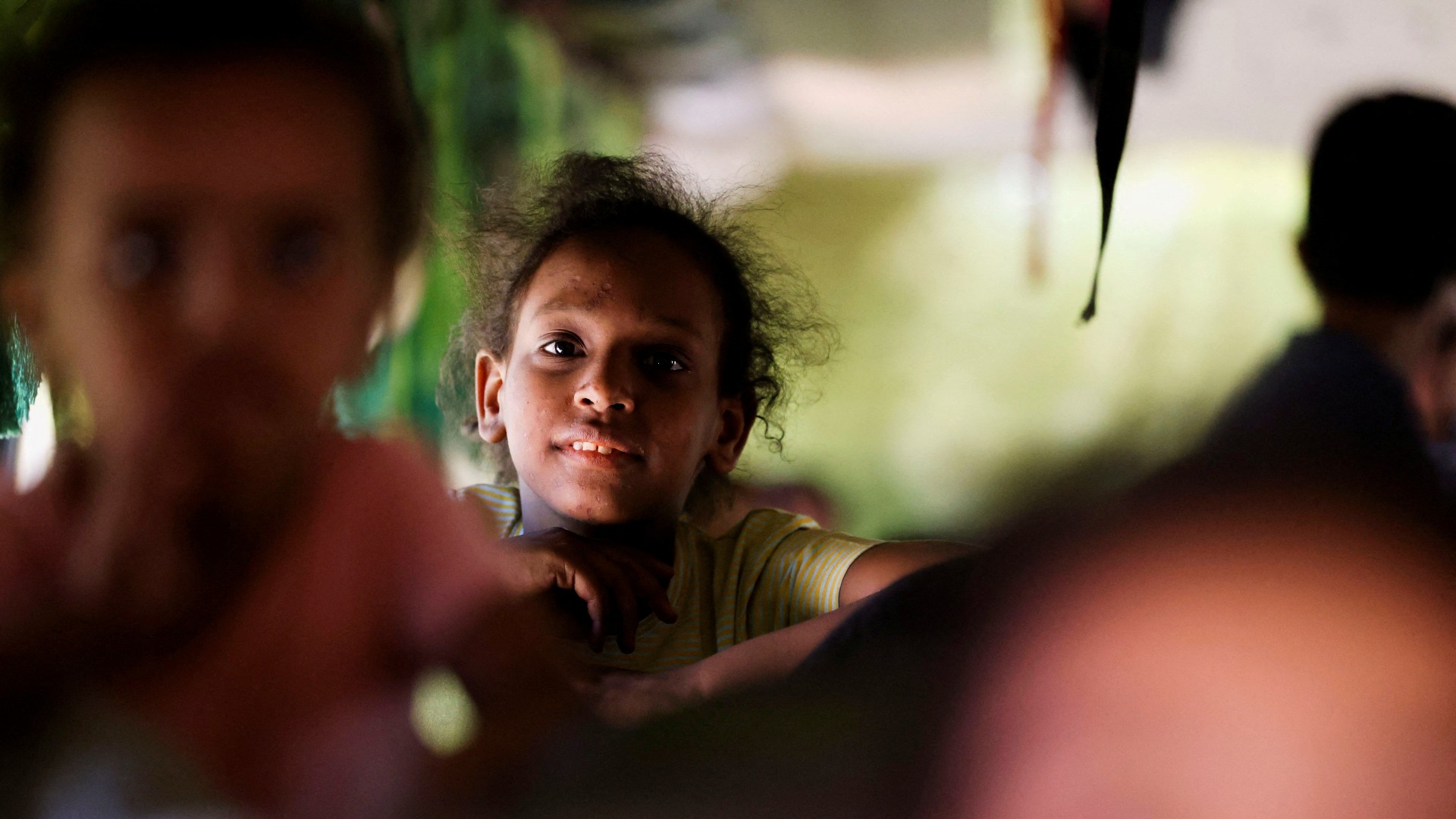A girl sits in a bus as passengers fleeing from Sudan arrive at the Argeen border crossing on 28 April (Reuters)
