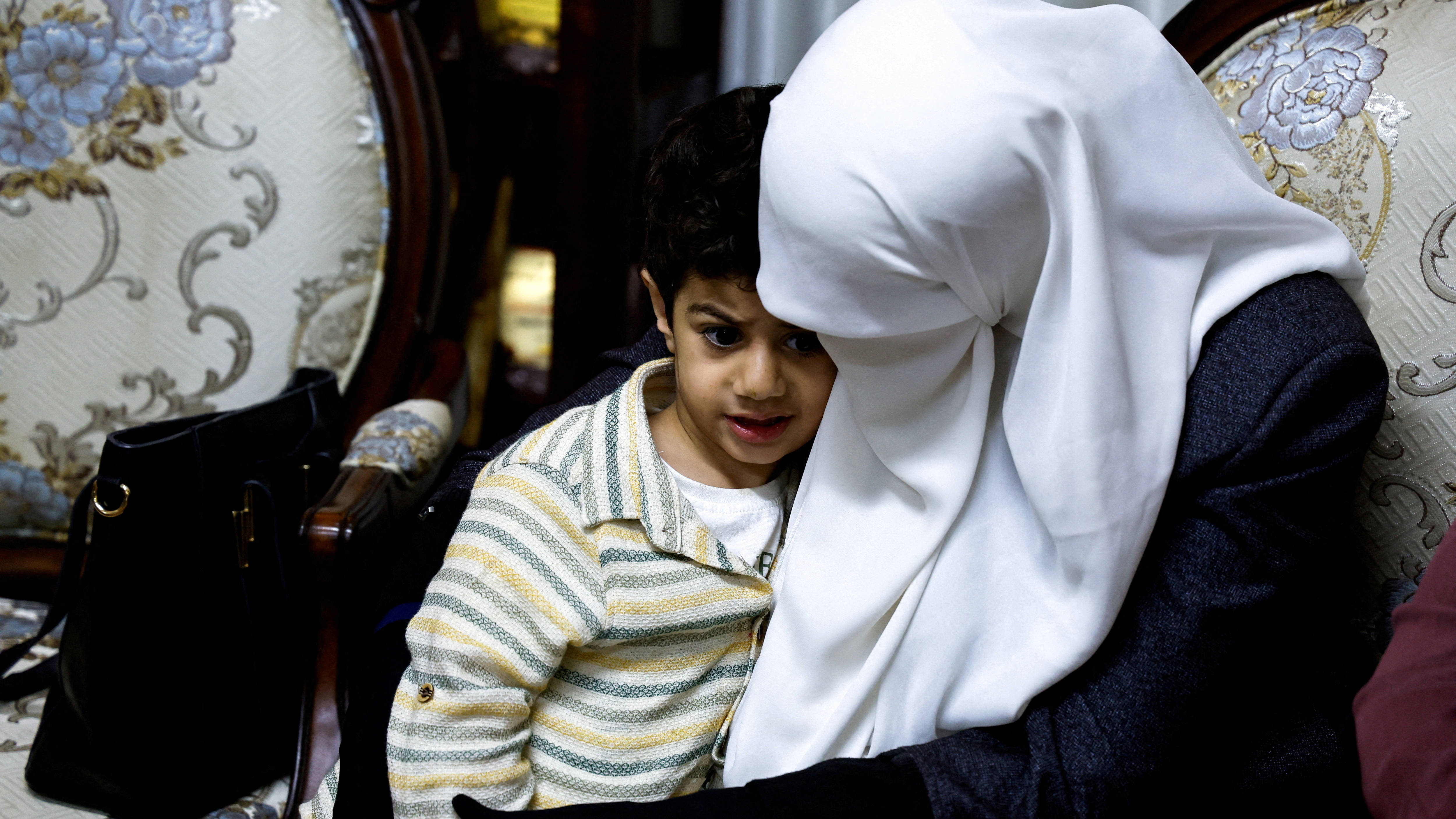 Randa Musa, Khader Adnan's wide, sits with their son Hamza, as Palestinians gather at their house, near Jenin in the occupied West Bank 2 May 2023 (Reuters)