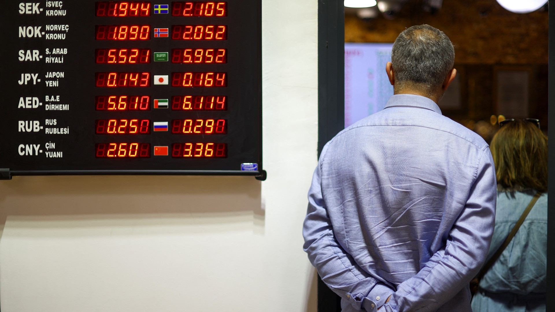 People queue at a currency exchange booth, following the first round of presidential and parliamentary elections, in Istanbul, 15 May (Reuters)