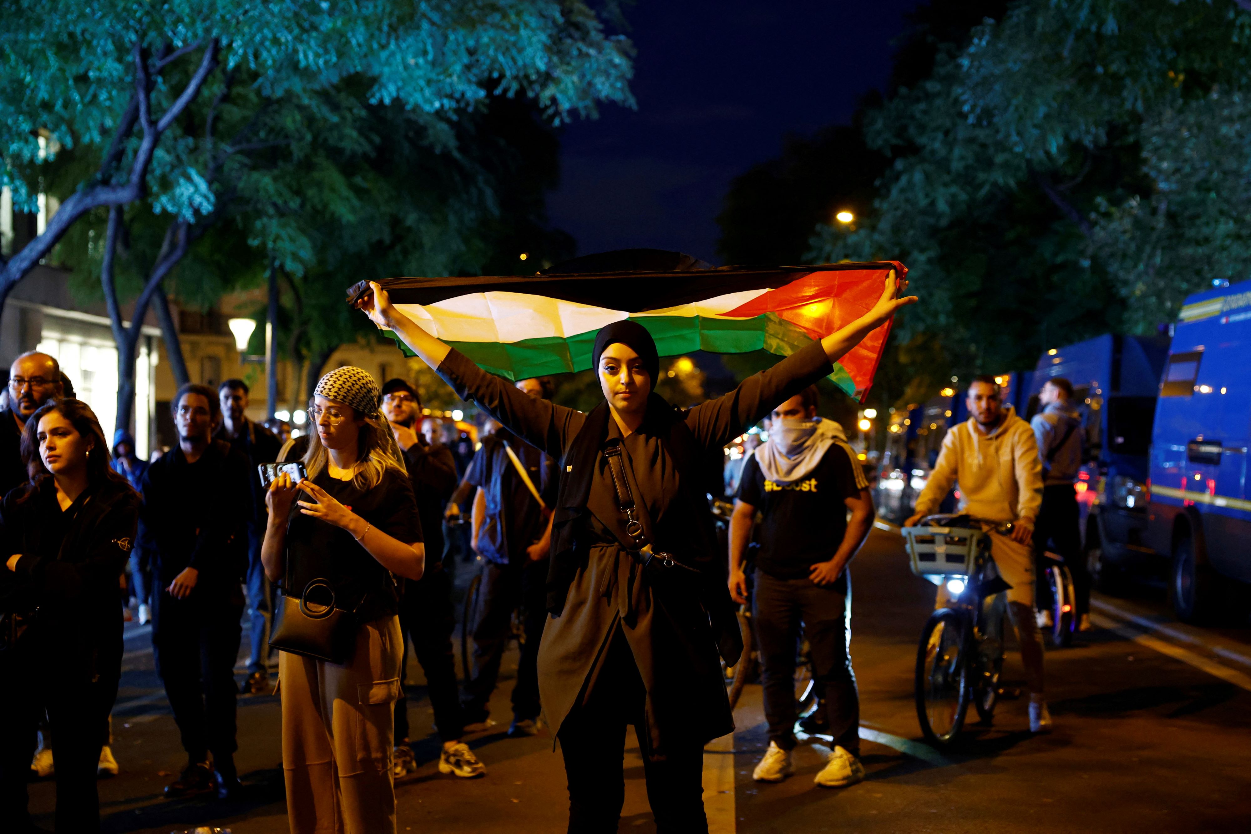 A woman holds a Palestinian flag during an unauthorized demonstration in support of Palestinians, as part of the ongoing conflict between Israel and Hamas (Reuters)