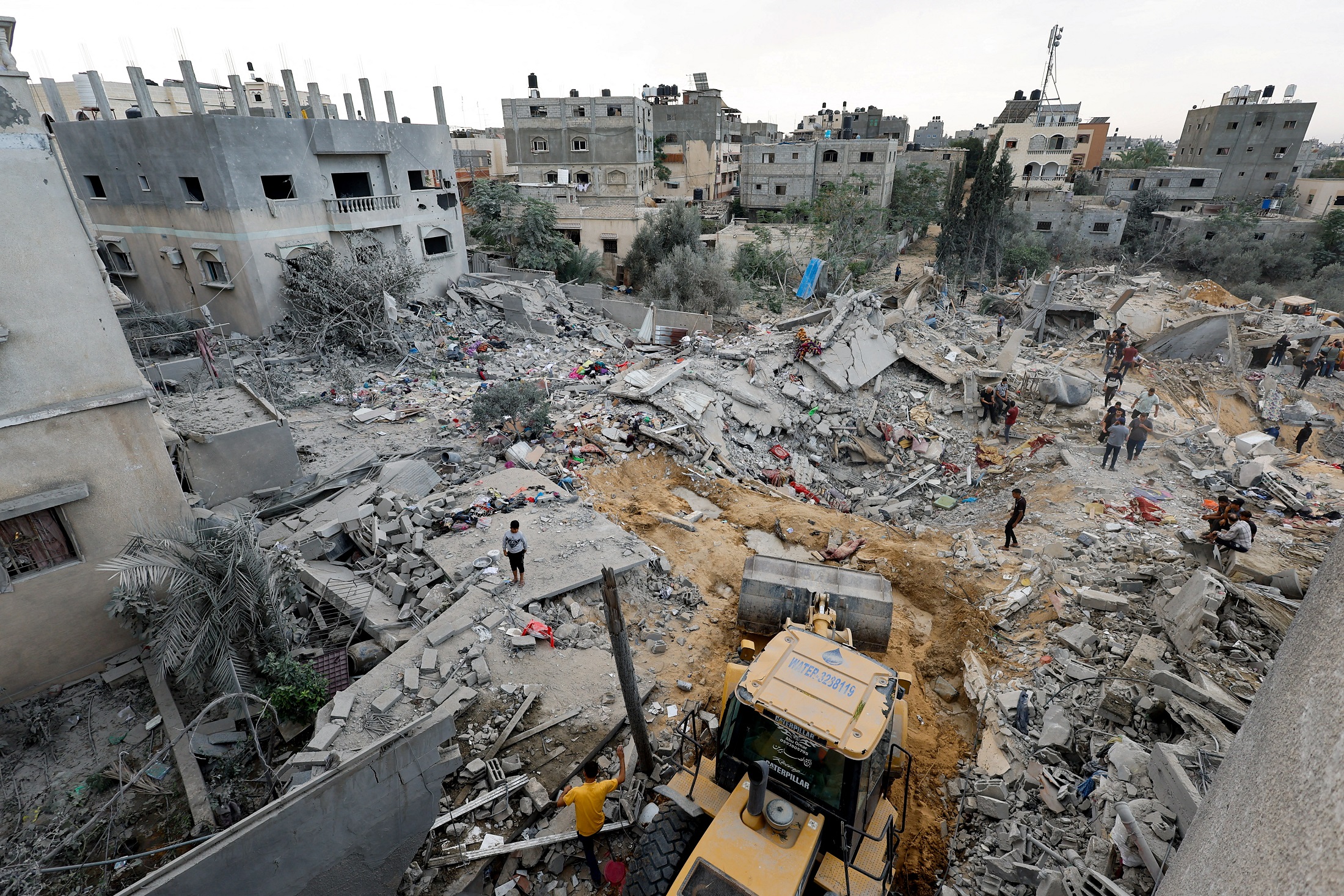 A man sits among rubble as Palestinians gather at the site of an Israeli strike, amid the ongoing conflict between Israel and the Palestinian group Hamas, in Khan Younis in the southern Gaza Strip November 12, 2023. REUTERS/Mohammed Salem
