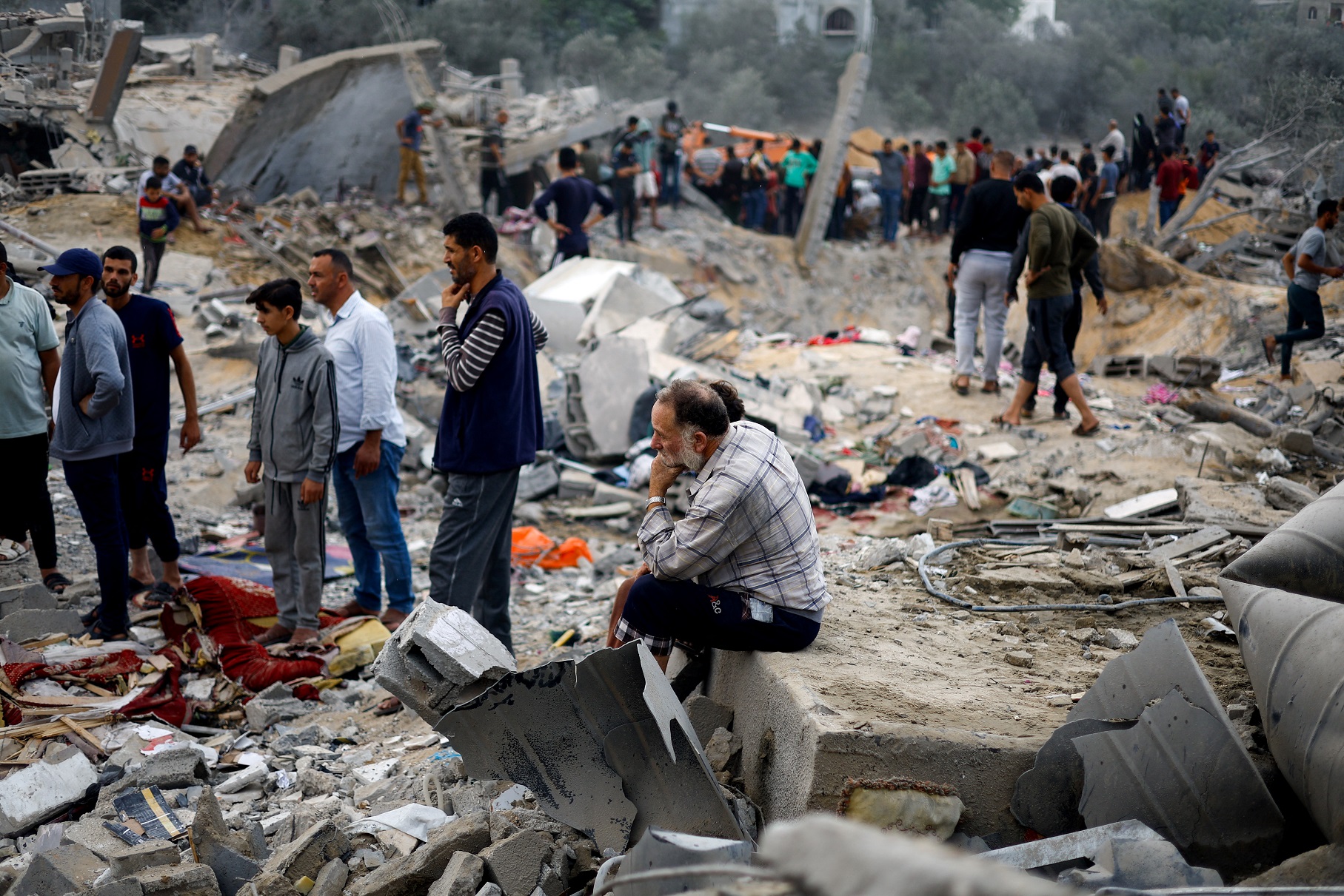 A man sits among rubble as Palestinians gather at the site of an Israeli strike, amid the ongoing conflict between Israel and the Palestinian group Hamas, in Khan Younis in the southern Gaza Strip November 12, 2023. REUTERS/Mohammed Salem