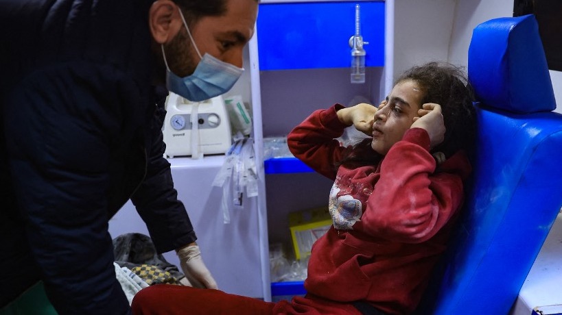 An injured girl sits in an ambulance following an Israeli air strike on the Rafah refugee camp in the southern Gaza Strip on December 1, 2023