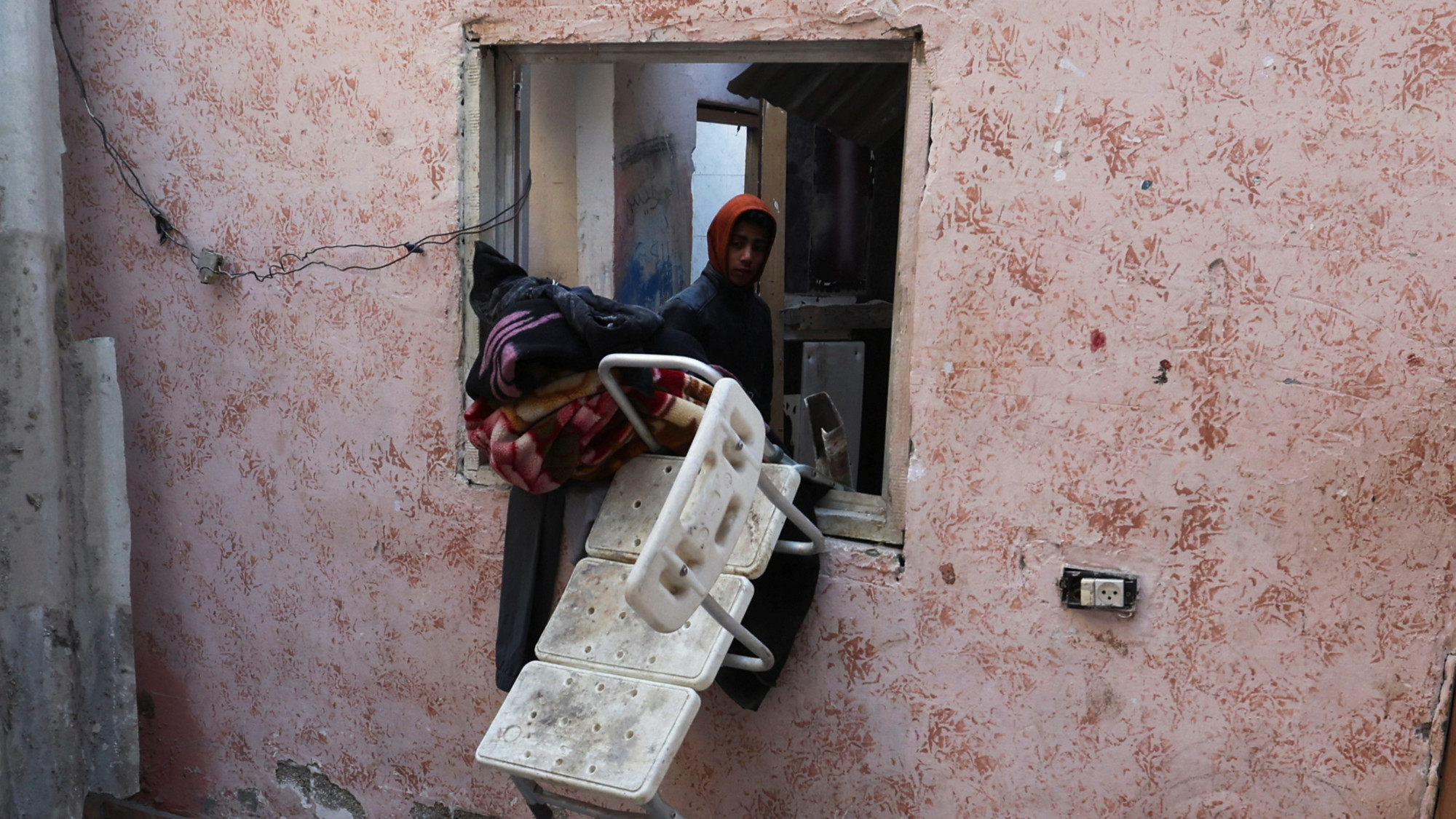 A Palestinian man looks on at the site of an Israeli strike in Rafah in the southern Gaza Strip 10 January 2024 (Ibraheem Abu Mustafa/Reuters)