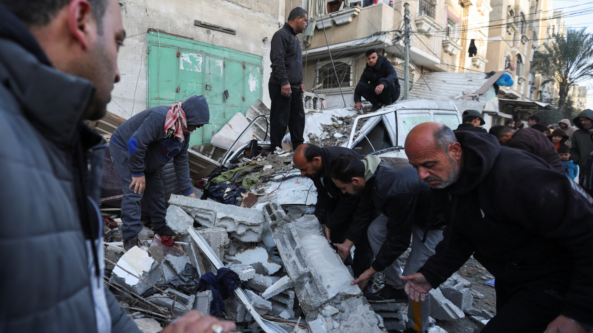 Palestinians inspect the site of an Israeli strike in Rafah in the southern Gaza Strip 10 January 2024 (Ibraheem Abu Mustafa/Reuters)