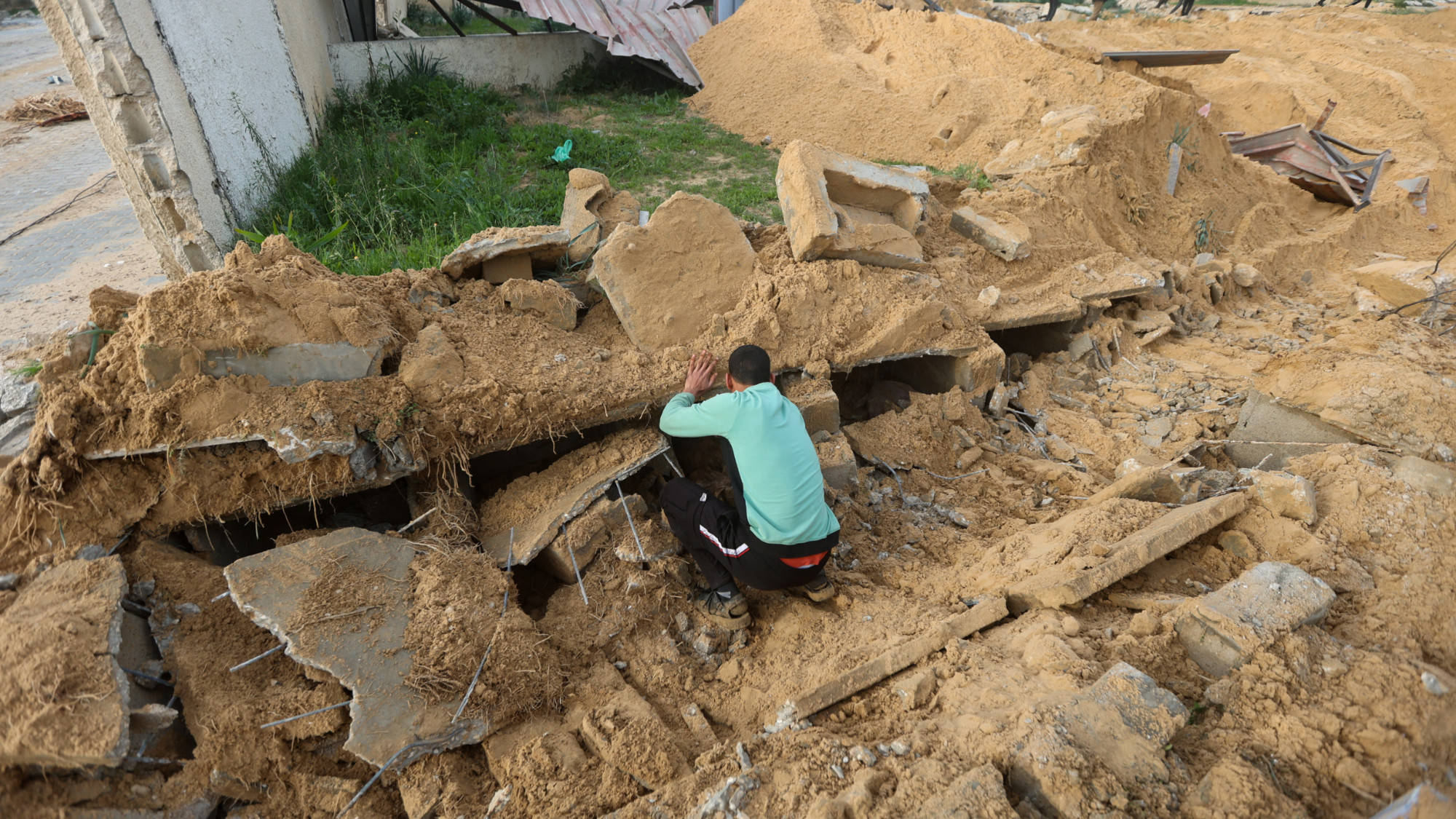 Palestinians check damaged graves at a cemetery following an Israeli raid in Khan Younis in the southern Gaza Strip 17 January 2024 (Ahmed Zakot/Reuters)