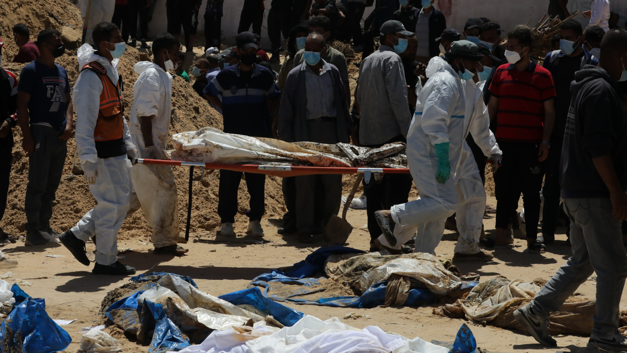 Palestinian civilians and the civil defence teams try to identify bodies found at a mass grave in Nasser hospital in Khan Yunis 22 April 2024 (Arab world press via Reuters)